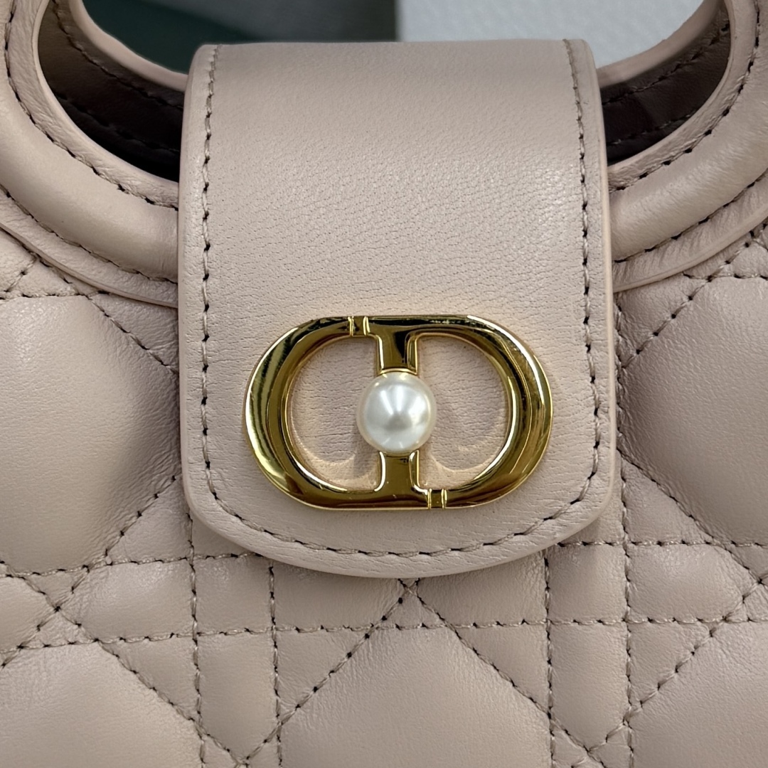 这款 Dior Jolie Top Handle 迷你链条手袋是二零二六早春成衣系列新品，呈现出优雅实用的设计。采用胭脂粉色羊皮革精心制作，饰以藤格纹，翻盖点缀以金色饰面金属 CD 标志和白色树脂珠饰。内设一个隔层，可收纳各种日常用品。搭配双顶部手柄和可调节、可拆卸 CD 链条肩带，肩带由皮革带和 CD 链环组成，饰以白色树脂珠饰，可舒适手提、肩背或斜挎，可与日常或晚装造型搭配。
主体：羊皮革
里料：羊皮革
磁性翻盖开合正面饰以 CD 扣环和白色树脂珠饰
1 个隔层
双顶部皮革手柄
可调节、可拆卸的链条饰以树脂珠饰和皮革带
意大利制造尺寸：18.5 x 13 x 8.5 厘米（长 x 高 x 宽）
可收纳 1 部手机、1 个卡夹、太阳眼镜和唇膏
编号: S3123
