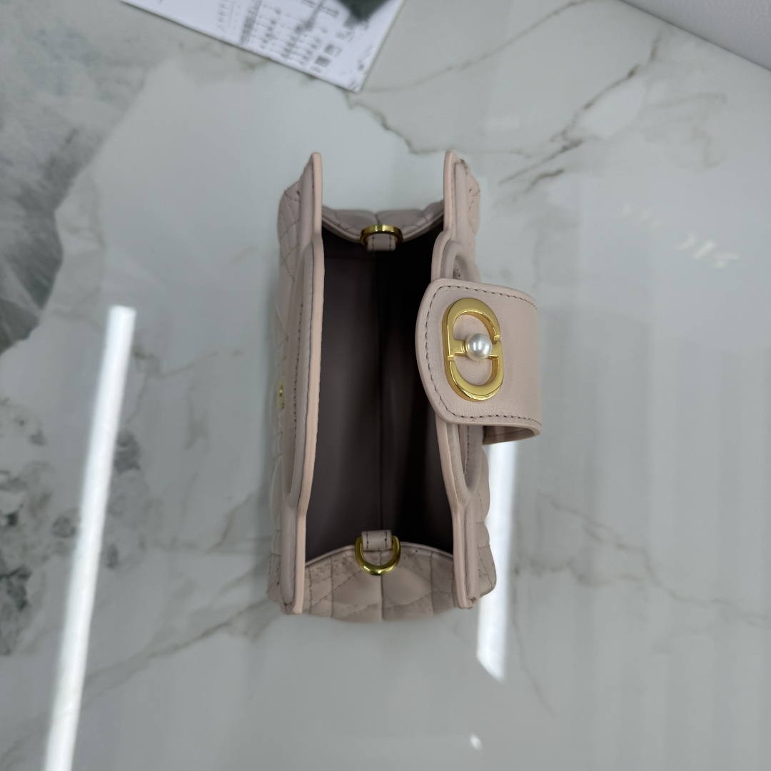 这款 Dior Jolie Top Handle 迷你链条手袋是二零二六早春成衣系列新品，呈现出优雅实用的设计。采用胭脂粉色羊皮革精心制作，饰以藤格纹，翻盖点缀以金色饰面金属 CD 标志和白色树脂珠饰。内设一个隔层，可收纳各种日常用品。搭配双顶部手柄和可调节、可拆卸 CD 链条肩带，肩带由皮革带和 CD 链环组成，饰以白色树脂珠饰，可舒适手提、肩背或斜挎，可与日常或晚装造型搭配。
主体：羊皮革
里料：羊皮革
磁性翻盖开合正面饰以 CD 扣环和白色树脂珠饰
1 个隔层
双顶部皮革手柄
可调节、可拆卸的链条饰以树脂珠饰和皮革带
意大利制造尺寸：18.5 x 13 x 8.5 厘米（长 x 高 x 宽）
可收纳 1 部手机、1 个卡夹、太阳眼镜和唇膏
编号: S3123