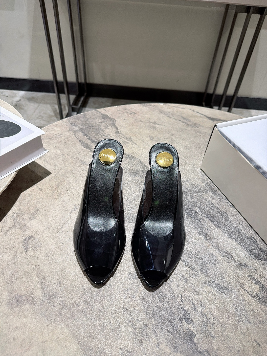 NO:921573,, Saint Laurent's 26 spring and summer new mules fish-mouth slippers, with the iconic transparent thick heel and the golden metal logo on the insole, the design is bold and highly recognizable. The film material has a glossy feel, and the transparent heel adds a sense of modernity and lightness. It is an eye-catching item that is 'heart-beating at first glance'. It is very suitable for matching with skirts or simple trousers. It can instantly enhance the sense of luxury and aura of the overall look, and is a powerful tool for creating a light luxury style.  Upper butter leather/special film Sheepskin lining/Sheepskin foot pads Heel height 7CM Genuine leather outsole size 35-40 (40 can be customized and non-returnable) Comes with original packaging, half-slip heels, saint laurent, saint laurent, high heels, slippers, skirts, sheepskin, Leather soles19860909, Saint Laurent圣罗兰26春夏新品穆勒鞋鱼嘴拖鞋,拥有标志性的透明粗跟和鞋垫处的金色金属Logo,设计大胆且极具辨识度.胶片材质自带光泽感,透明鞋跟增加了现代感和轻盈度,属于“一眼心动”的吸睛单品. 非常适合搭配裙装或简约裤装,能瞬间提升整体造型的高级感和气场,是打造轻奢风的利器. 鞋面牛油皮/特制胶片 羊皮里/羊皮垫脚 跟高7CM 真皮大底 size35-40(40定做不退换) 配原版一致包装,半拖高跟鞋,saint laurent,saint laurent,high heels,slippers,skirts,sheepskin,Leather soles,Women's Shoes