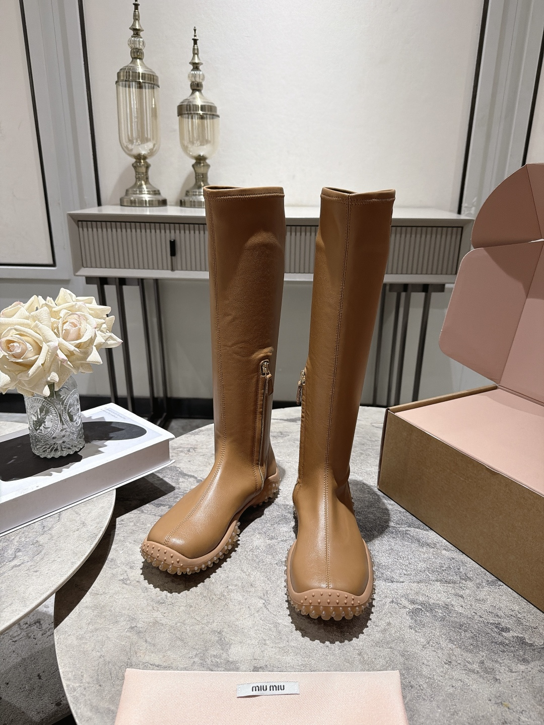 NO:921562,, MIU Miu's 26 autumn and winter new round-toe high-top thick-soled boots have a fashionable design and high-end texture. They are a 'high-profile artifact' and 'atmosphere-sense' in autumn and winter wear. The boot body is made of soft leather, which fits the foot shape and is comfortable to wear without tiring the feet. It adopts a thick-soled design and has non-slip texture on the sole, taking into account both fashion and practicality. It visually lengthens the leg line and is suitable for small people or wearers who pursue heightening effects.  Pair it with a short skirt or tights to highlight the length of your legs and create a 'leg essence' effect; pair it with a coat or down jacket to enhance the fashion and luxury of the overall look; suitable for daily commuting, dating or light outdoor activities, with both appearance and functionality. Size: 35-40 (custom-made 40 pieces are non-returnable) Comes with original packaging (airplane box), boots, miumiu, boots, skirts, down jacket19860909, MIU Miu 缪缪26秋冬新品圆头高筒厚底长靴,设计时尚、质感高级,是秋冬穿搭中的”显高神器”和”氛围感担当” 靴身由柔软皮革制成,贴合脚型,穿着舒适不累脚；采用厚底设计,鞋底带有防滑纹路,兼顾时尚与实用性.视觉上拉长腿部线条,适合小个子或追求显高效果的穿搭者. 搭配短裙或紧身裤,凸显腿长,打造”腿精”效果；搭配大衣或羽绒服,提升整体造型的时髦度与高级感；适合日常通勤、约会或轻度户外活动,兼具颜值与功能性. 码数:35-40(40定做不退换) 配原版一致包装(飞机盒),靴子,miumiu,boots,skirts,down jacket,Women's Shoes