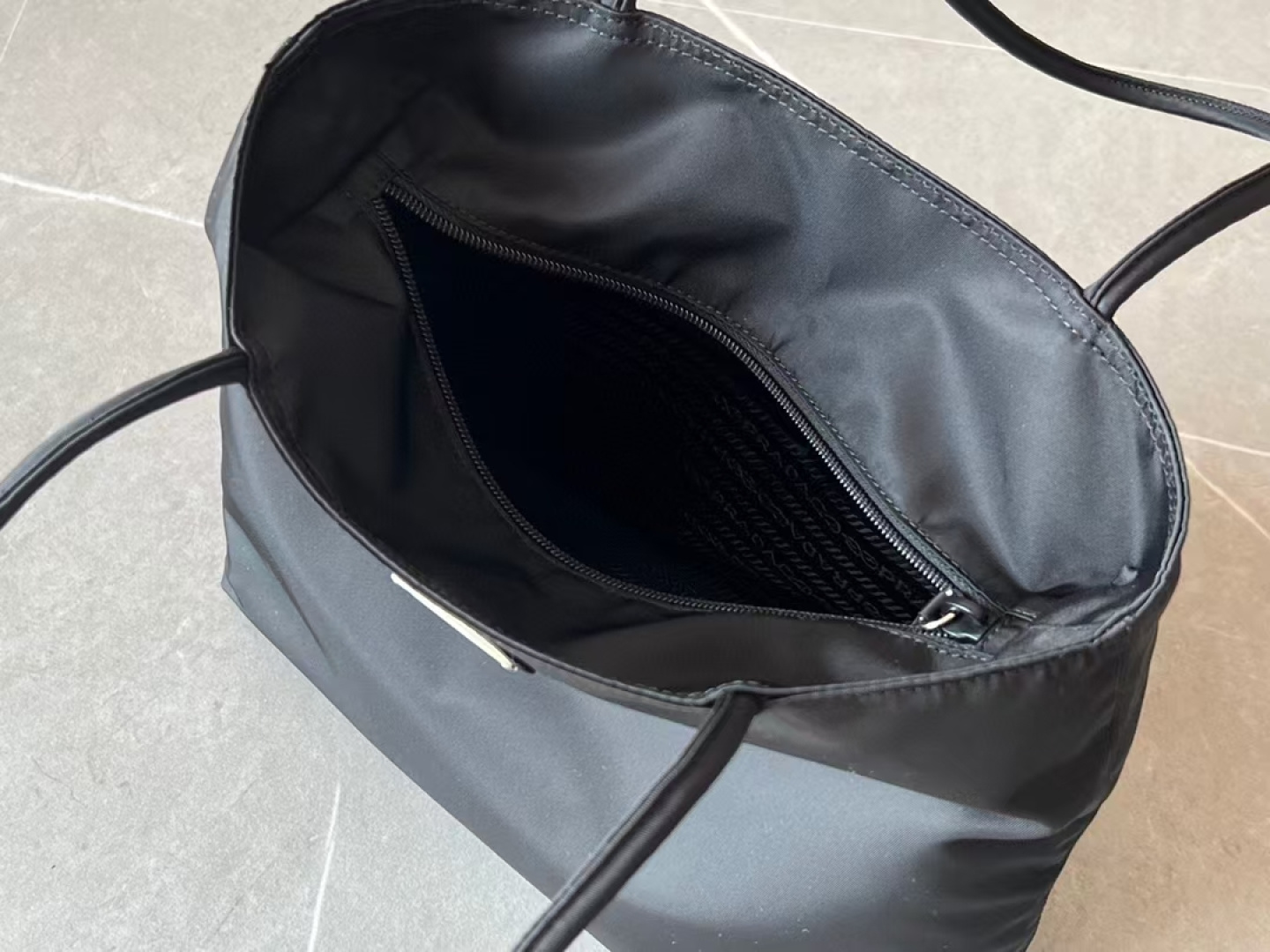 Prada The design of the shopping bag has a zipper opening and closing in the middle. It can be carried on the shoulder or in the hand, and the ca