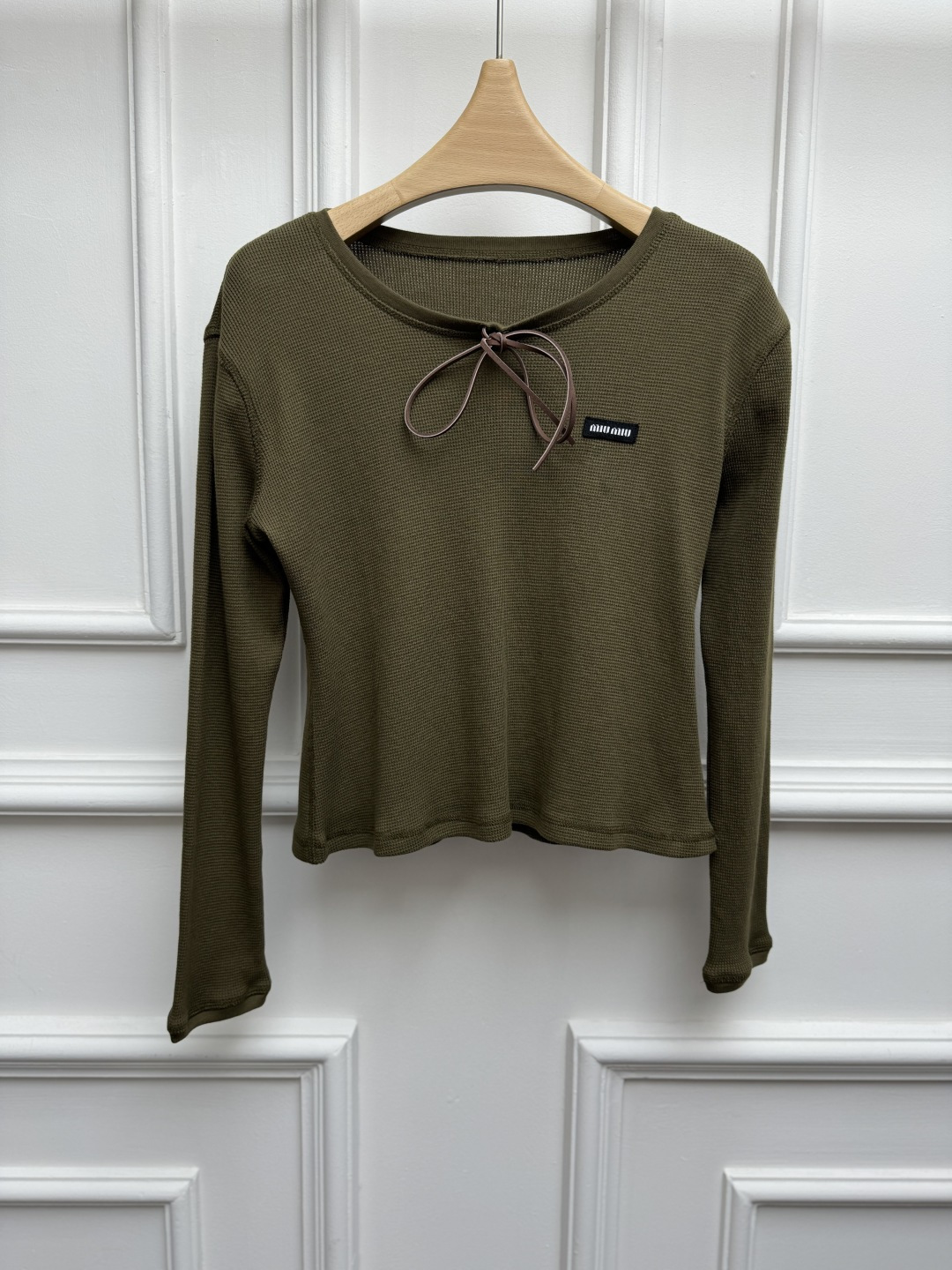 NO:869762,New spring and summer models are available. Miu lace-up long-sleeved T-shirt 2026 spring and summer series. Versatile U-shaped neckline. Contrast bow tie design. Logo embroidery on the chest. Sweet and fashionable to reduce age. A must-have for hot girls. Waffle cotton fabric. Elastic slim fit. The upper body is slim and elegant. Sizes SML,,miumiu,tees,t-shirt,19860909春夏新款上新啦 Miu系带长袖T恤 2026春夏系列 百搭U字领领口 撞色蝴蝶结系带设计 胸前logo徽标刺绣点缀 甜美时髦减龄 辣妹必备 华夫格棉面料 弹力修身版型 上身显瘦又气质 尺码SML,,miumiu,tees，t-shirt,,Women's clothing