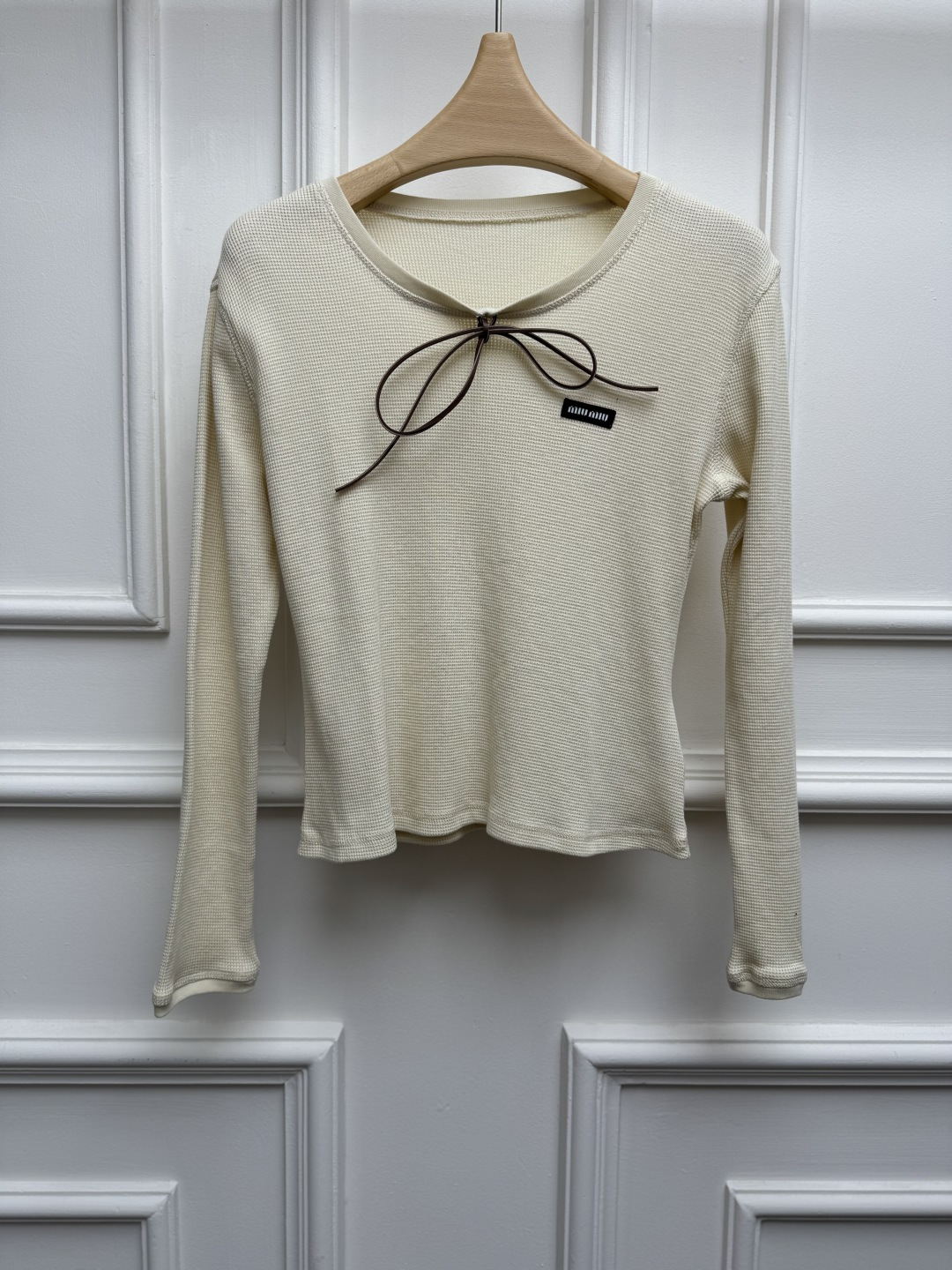 NO:869767,New spring and summer models are available. Miu lace-up long-sleeved T-shirt 2026 spring and summer series. Versatile U-shaped neckline. Contrast bow tie design. Logo embroidery on the chest. Sweet and fashionable to reduce age. A must-have for hot girls. Waffle cotton fabric. Elastic slim fit. The upper body is slim and elegant. Sizes SML,,miumiu,tees,t-shirt,19860909春夏新款上新啦 Miu系带长袖T恤 2026春夏系列 百搭U字领领口 撞色蝴蝶结系带设计 胸前logo徽标刺绣点缀 甜美时髦减龄 辣妹必备 华夫格棉面料 弹力修身版型 上身显瘦又气质 尺码SML,,miumiu,tees，t-shirt,,Women's clothing
