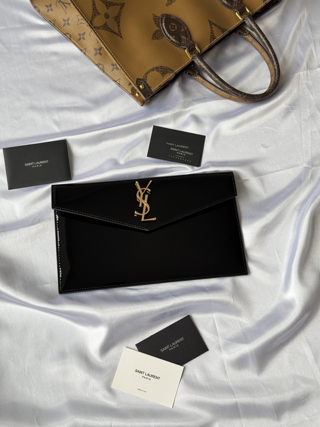 Yves Saint Laurent Black Patent Leather Clutch with Gold Logo 2 cmp i1743757038263 4892 0 0