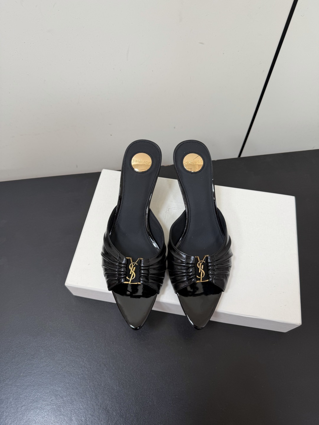 NO:867034,Saint Laurent Metal Buckle Pleated Sandals The pleated design of the YSL upper is like rubbing the delicacy from retro pictorials into the shoes. The pointed stiletto heels outline neat lines and are embellished with metal buckles. Every step brings just the right amount of nobility and style.  It is an 'atmosphere artifact' that makes people fall in love at a glance. The complexity is eliminated, leaving only pure texture and lines. The pleated leather is the finishing touch, showing exquisiteness in simplicity. Whether it is paired with a suit or a dress, it can easily hold the audience. Who can resist a pair of pleated mules with its own elegant buff?  The pointed toe lengthens the leg shape and the pleats add softness. From commuting to dating, it is your safest choice, making you low-key and dazzling in the crowd. Upper cowhide leather lining sheepskin sole Italian genuine leather outsole Heel height 5.5cm Size 35-41 (40.41 customized non-refundable), high heels and slippers, saint laurent, saint laurent, high heels, slippers, skirts, business  suit,cowhide,sheepskin,leather soles19860909Saint Laurent 金属扣褶皱凉拖鞋 Ysl鞋面的褶皱设计,像把复古画报里的精致揉进了鞋里.尖头细高跟勾勒出利落线条,金属扣点缀其间,每一步都带着恰到好处的贵气与风情, 是让人一眼沦陷的“氛围感神器”.褪去繁杂,只留纯粹的质感与线条.褶皱皮革是点睛之笔,在简约中透出精致,不管是搭配西装还是连衣裙,都能轻松hold住全场. 谁能拒绝一双自带优雅buff的褶皱穆勒鞋？尖头拉长腿型,褶皱增添柔媚,从通勤到约会,它都是你最稳妥的选择,让你在人群中,低调又耀眼. 鞋面牛皮 内里羊皮 鞋底意大利真皮大底 跟高5.5cm 码数35-41（40.41定制不退换）,高跟鞋拖鞋,saint laurent,saint laurent,high heels,slippers,skirts,business suit,cowhide,sheepskin,Leather soles,Women's Shoes