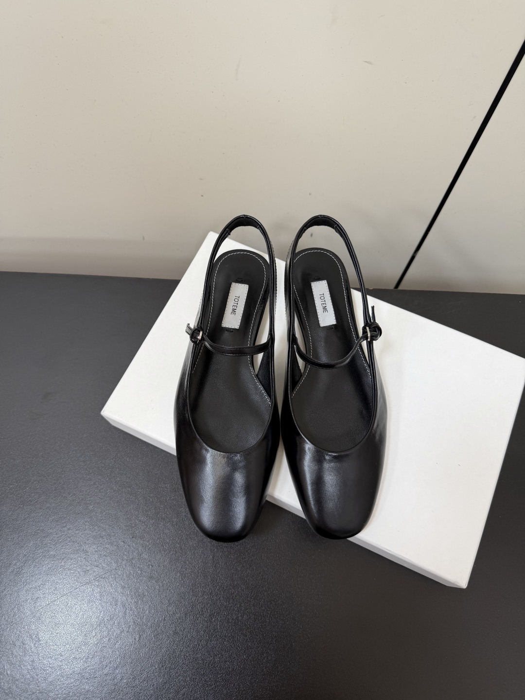 NO:903244,Toteme's new classic back-space Mary Jane shoes. The Scandinavian minimalist design that catches your eye at first glance perfectly interprets TOTEME's cool and high-end sense. The neat square-toe shoe shape perfectly modifies the foot shape, making the foot smaller in seconds, and easily creating a slender and slender visual effect. The back-space trip strap + adjustable buckle design makes it easy to put on and take off, while perfectly fitting the ankle, walking steadily without grinding the feet, saying goodbye to the constrained feeling of traditional single shoes.  The flat design can be worn for a long time without tiring the feet, and can be easily used for daily commuting, dating parties, and formal occasions. It truly achieves the coexistence of appearance and comfort. It is an evergreen model that will never go out of style in the shoe cabinet. Butter leather upper, sheepskin lining, Italian genuine leather outsole, size 35-41 (customized sizes 40 and 41 are non-returnable), sandals, sandals, mary jane, sheepskin, Leather soles19860909Toteme新款经典后空玛丽珍单鞋 一眼沦陷的北欧极简设计,将TOTEME的清冷高级感完美诠释.利落的方头鞋型,极致修饰脚型,秒显脚小,轻松打造纤细修长的视觉效果；后空绊带+可调节搭扣设计,穿脱便捷,同时完美贴合脚踝,走路稳当不磨脚,告别传统单鞋的束缚感. 平底设计久穿不累脚,日常通勤、约会聚会、正式场合都能轻松驾驭,真正做到了颜值与舒适并存,是鞋柜里永不过时的常青款. 鞋面牛油皮 内里羊皮 大底意大利真皮大底 size35-41码（40、41码定制不退换）,凉鞋,sandals,mary jane,sheepskin,Leather soles,Women's Shoes