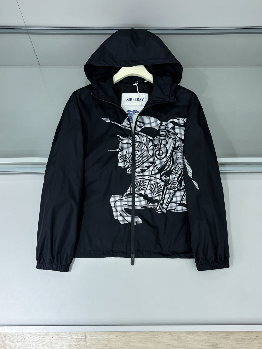 NO:488642,Layout details Burber Equestrian Knight Logo Surfing Jacket Jacket The fabric is made of high-quality nylon fabric, with lightness, LL1670350 wear resistance, windproof and waterproof, which is very suitable for making casual jackets. In the fabric treatment, special waterproof coating treatment technology is used to enhance its waterproof performance. Cut and sew the fabric into the required shape and size according to the design drawings. Use advanced sewing equipment and technology to sew the fabric together to form the overall structure of the jacket. During the sewing process, special attention should be paid to the details, such as sewing of zippers, pockets, cuffs, etc., to ensure its firmness and aesthetics. A very accurate restoration of the logo pattern is required. Logo and printing treatment Decorate the Equestrian Knight logo (EKD) and B-shaped zipper heads on the jacket through glue printing to highlight the brand characteristics.  Printing treatment uses environmentally friendly and washable pigments to ensure that the printing is long-lasting and bright. Drawstring hood and hem design can adjust the tightness according to weather changes to provide better protection. Back-fitting and inspection The sewn jacket is processed afterwards, such as ironing, thread removal, etc., to make it more flat and beautiful. Strict quality inspection SIZE:S-XL,,burberry, jackets & coats,jackets & coats,hats,alexander wang19860909铺排细节 Burber马术骑士徽标 冲锋衣夹克外套 面料由高品质的尼龙面料,具有轻盈、LL1670350耐磨、防风防水等特性,非常适合制作休闲夹克. 在面料处理上,采用特殊的防水涂层处理技术,以增强其防水性能. 裁剪与缝制 根据设计图纸,将面料裁剪成所需形状和尺寸. 使用先进的缝制设备和技术,将面料缝制在一起,形成夹克的整体结构. 在缝制过程中,特别注意细节处理,如拉链、口袋、袖口等部位的缝制,确保其牢固度和美观度. 需要非常精准的还原徽标图案 徽标与印花处理 通过胶浆印花将马术骑士徽标（EKD）和B字型拉链头装饰在夹克上,彰显品牌特色. 印花处理采用环保、耐洗的颜料,确保印花持久、鲜艳. 抽绳式连帽与衣摆设计,可根据天气变化调整松紧度,提供更好的防护效果. 后整与检验 对缝制好的夹克进行后整处理,如熨烫、去线头等,使其更加平整、美观. 进行严格的质量检验 SIZE:S-XL,,burberry,jackets & coats,jackets & coats,hats,alexander wang,Men's clothing