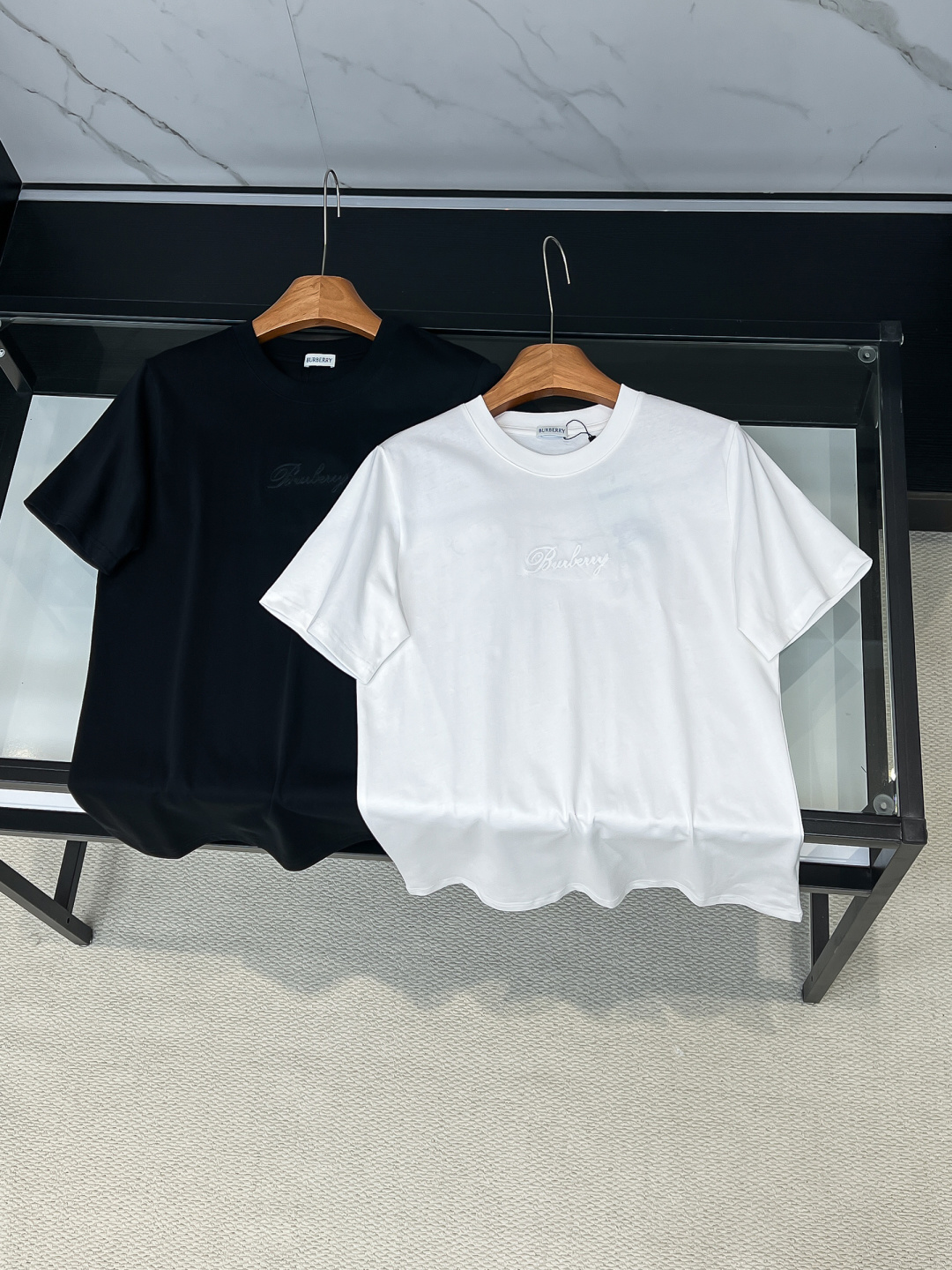 NO:685825,2026SS new product BUR spring and summer hand-made appliqué and high-density hemming embroidery round-neck short sleeves. The latest short-sleeve style adopts inherited hand-made appliqué. Hemming embroidery is a form of high-density embroidery, which is in the same category as the patch embroidery in Chinese Suzhou embroidery!  The embroidery method is to cut the applique cloth according to the pattern requirements and paste it on the embroidery surface, and insert cotton and other materials between the applique cloth and the embroidery surface to make the short-sleeved pattern bulge and have a three-dimensional effect. After the applique cloth is pasted, various stitches are used to lock the edges. The appliqué embroidery method mainly focuses on pattern blocks, and the style is unique and elegant!  After that, a high-density embroidery machine with 10,000 needles is used to position, fix, and cover. The appliqué embroidery uses embroidery that is different from the color of the short sleeves, which enhances the color jump and playful design, making it more eye-catching than a single cloth color!  Thousand-needle hemming, high-density hand-made appliqué and double embroidery technology make the whole dress show exquisite craftsmanship. Retro and classic are vividly displayed on this dress!  The patterns on the front and back of the clothes are all made of appliqué embroidery and high-density embroidery on the edges. No matter from which angle you look at it, it shows a low-key and luxurious fashion sense. It is an outstanding and eye-catching classic style that stands out among many spring and summer new styles!  The latest release, the exclusive release, the same style for men and women, classic, simple and versatile, the quality is unquestionable!  Color Black White Size S-2XL, burberry, T-shirt,198609092026SS 新品 BUR春夏手工贴布绣加高密度包边刺绣圆领短袖 最新款短袖采用传承的手工贴布绣,包边绣是高密度刺绣的一种刺绣形式,与中国苏绣中的贴续绣属同一类！其绣法是将贴花布按图案要求剪好,贴在绣面上,更在贴花布与绣面之间衬垫棉花等物,使此款短袖图案隆起而有立体感,贴好贴花布后,再用各种针法锁边.贴布绣绣法主要以图案块面为主,风格别致大方！之后再以万针高密度绣花机 定位 固定 覆盖,贴布绣使用与短袖颜色不相同的刺绣,加强了颜色的跳跃、俏皮的设计感,比单一本布色更加亮眼！万针包边高密度手工贴布绣双重刺绣工艺使整件衣服尽显精湛工艺,复古与经典在这款衣服上展现的淋漓尽致！衣服前后图案均采用贴布绣、包边高密度刺绣,不管从哪个角度看都尽显低调奢华的时尚感,是众多春夏新款中脱颖而出,出类拔萃,抢眼夺目,不可缺少的经典款！ 最首发 独家首发 男女同款 经典简约百搭 质感毋庸置疑！ 颜色黑色 白色 尺码S-2XL,,burberry,T-shirt,,Men's clothing