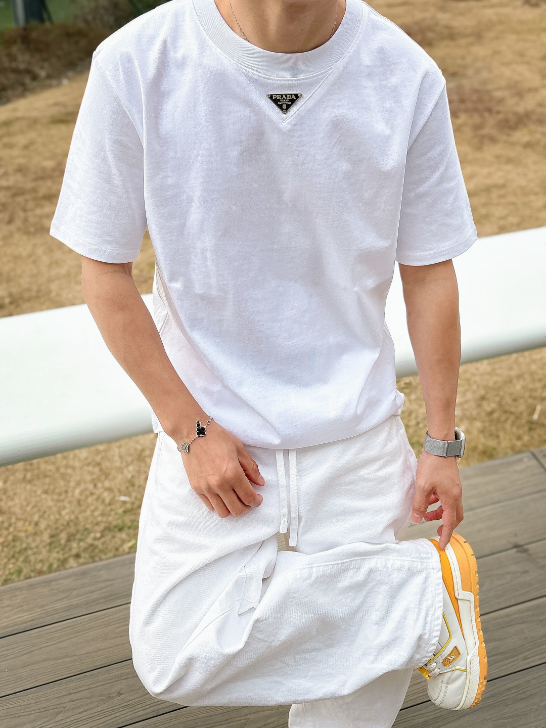 Prada 26ss春夏新品经典标识涂珐琅金属三角形徽标短袖T恤，正面胸前饰有品牌经典标志性三角形金属标