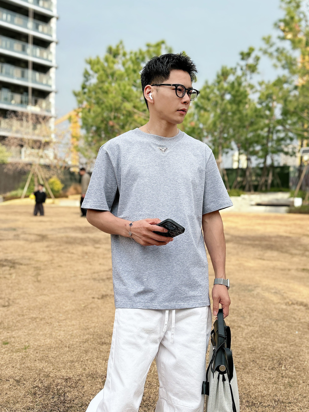 Prada 26ss春夏新品经典标识涂珐琅金属三角形徽标短袖T恤，正面胸前饰有品牌经典标志性三角形金属标