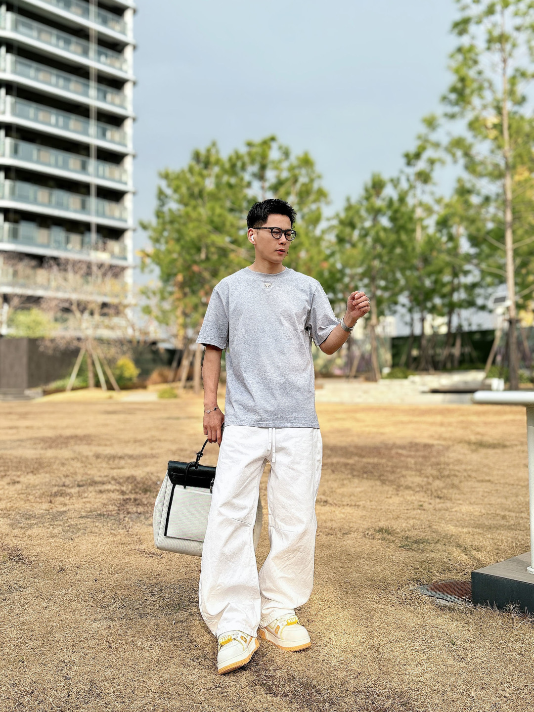 Prada 26ss春夏新品经典标识涂珐琅金属三角形徽标短袖T恤，正面胸前饰有品牌经典标志性三角形金属标