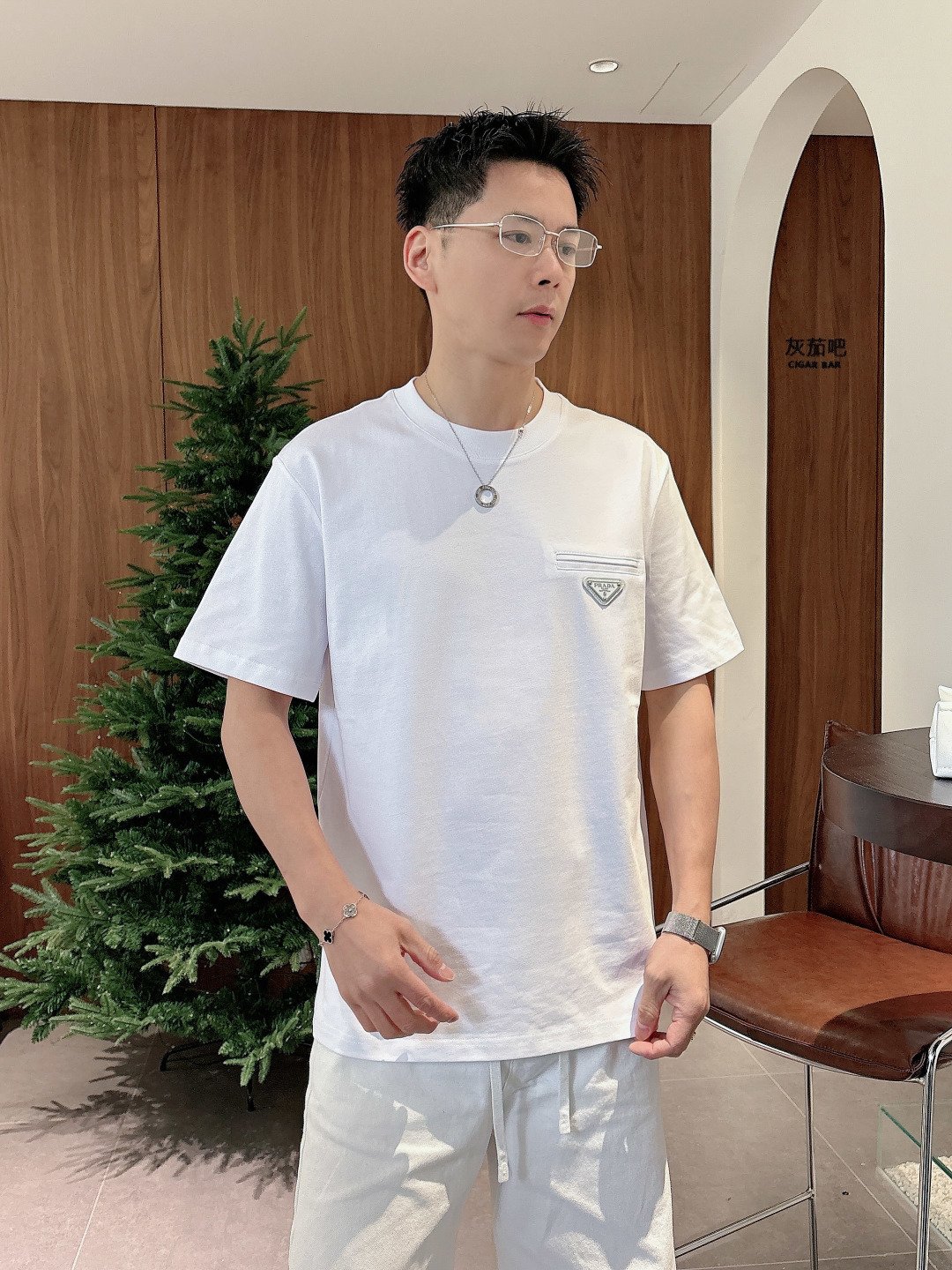 Prada 26ss春夏新品经典标识涂珐琅金属三角形徽标短袖T恤，正面胸前饰有品牌经典标志性三角形金属标