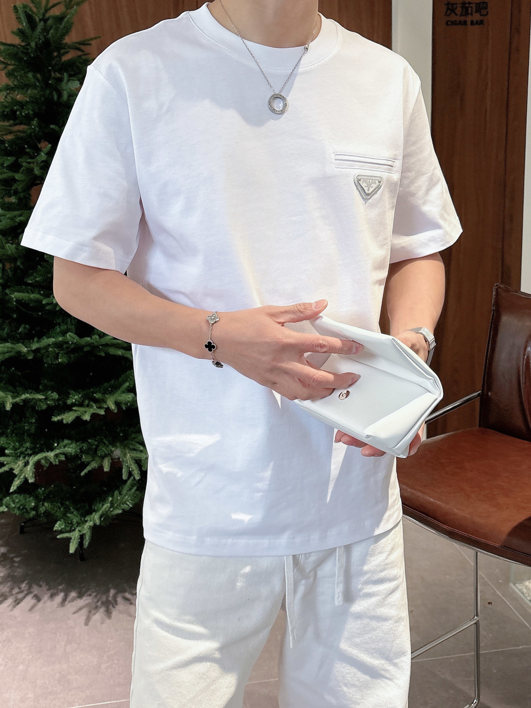 Prada 26ss春夏新品经典标识涂珐琅金属三角形徽标短袖T恤，正面胸前饰有品牌经典标志性三角形金属标