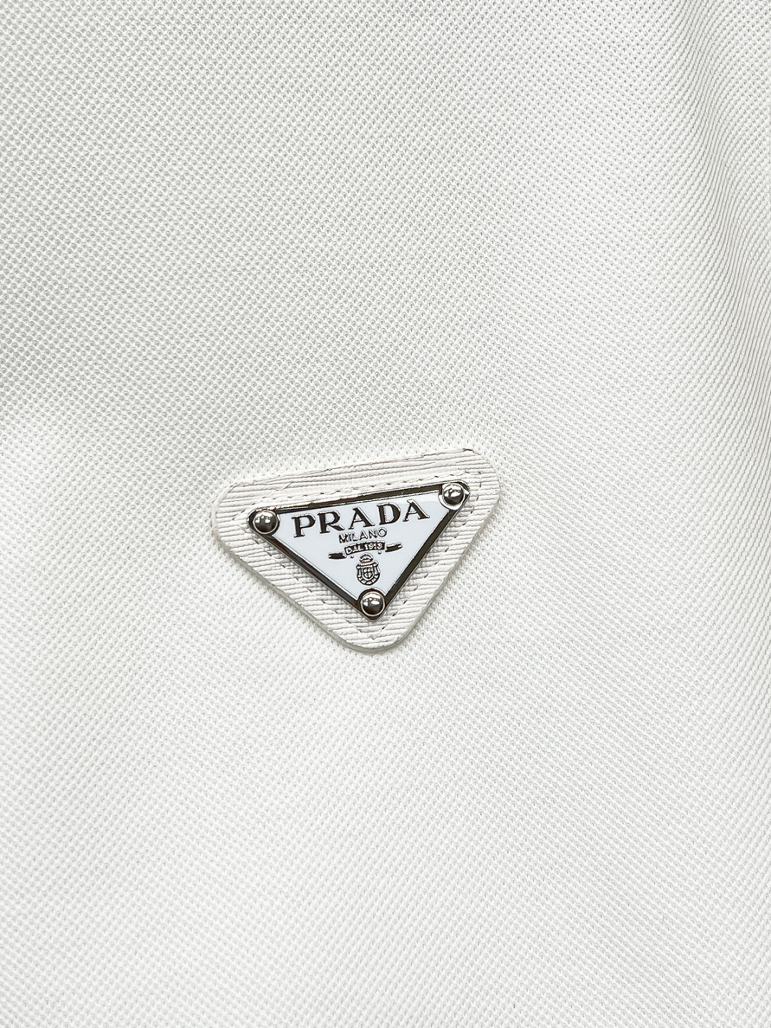 Prada.普拉达 SS26春夏新品经典金属三角形徽标Polo衫，以最简约的形式呈现，体现了休闲雅致风格