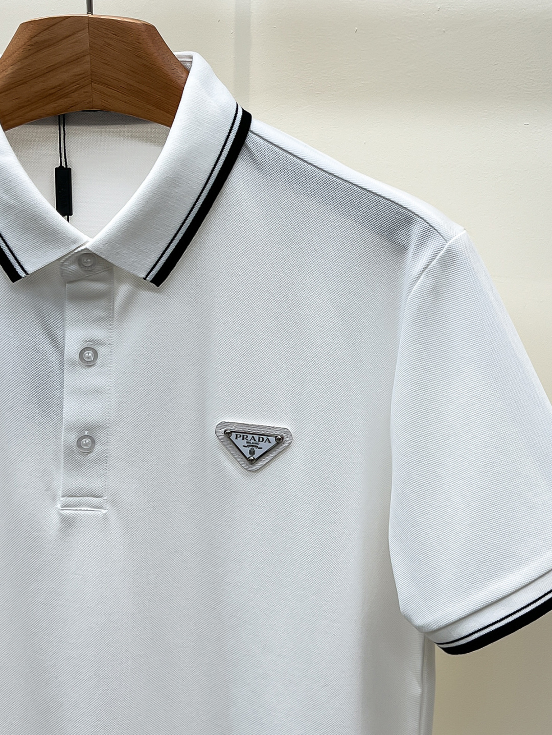 Prada.普拉达 SS26春夏新品经典金属三角形徽标Polo衫，以最简约的形式呈现，体现了休闲雅致风格