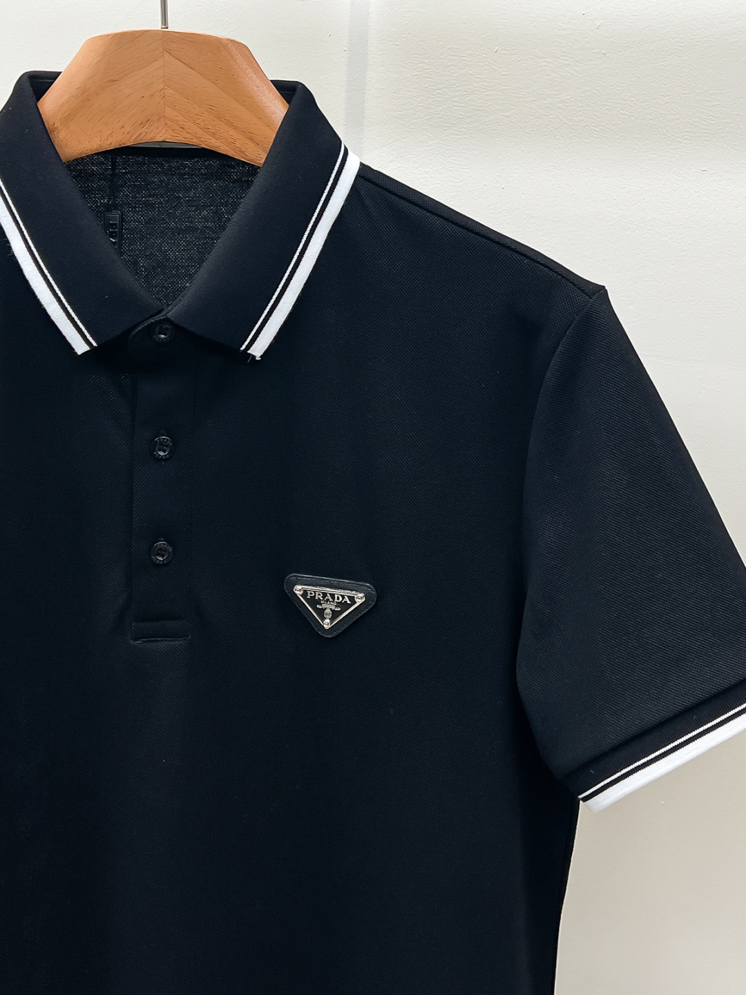 Prada.普拉达 SS26春夏新品经典金属三角形徽标Polo衫，以最简约的形式呈现，体现了休闲雅致风格