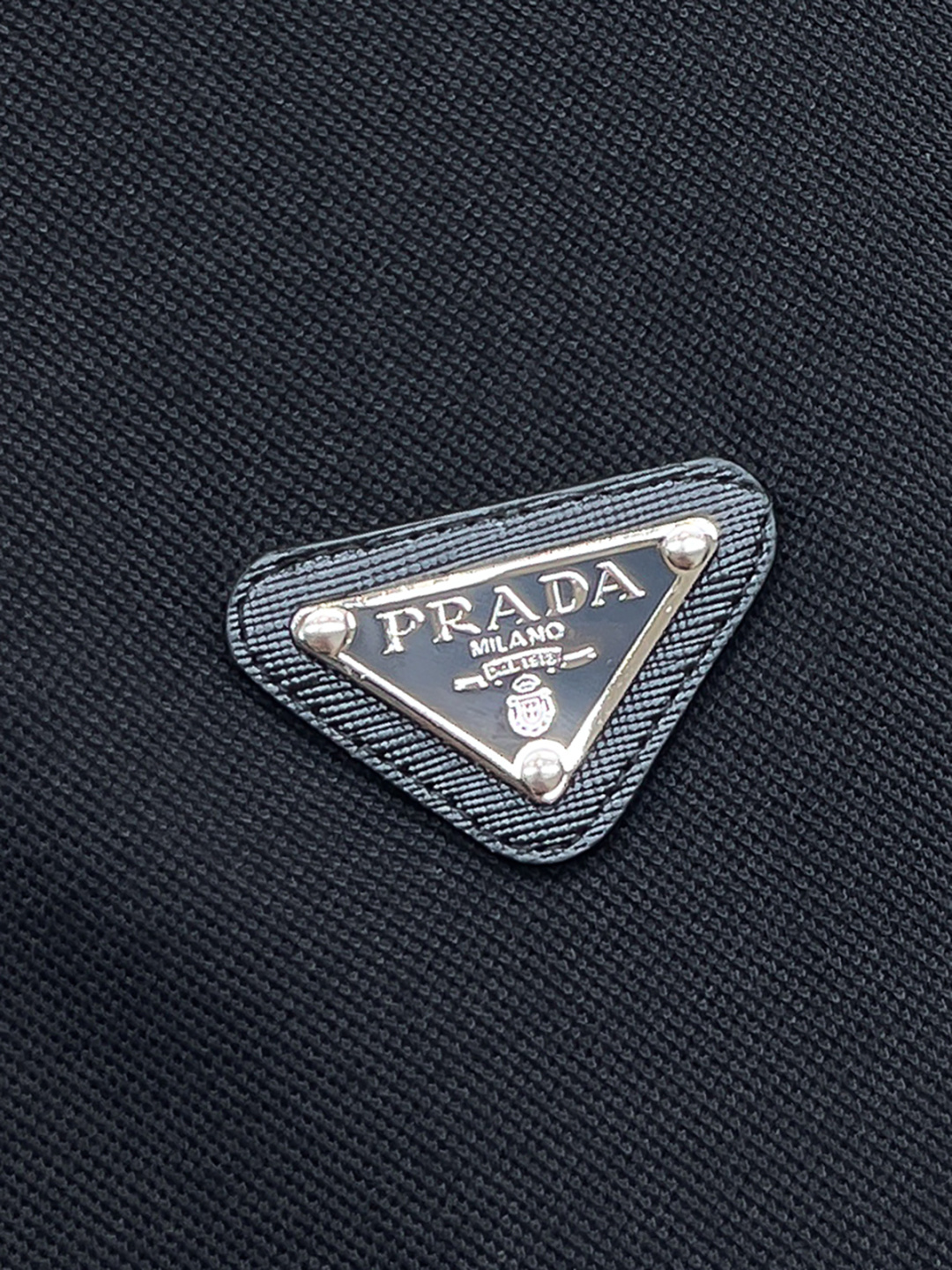 Prada.普拉达 SS26春夏新品经典金属三角形徽标Polo衫，以最简约的形式呈现，体现了休闲雅致风格