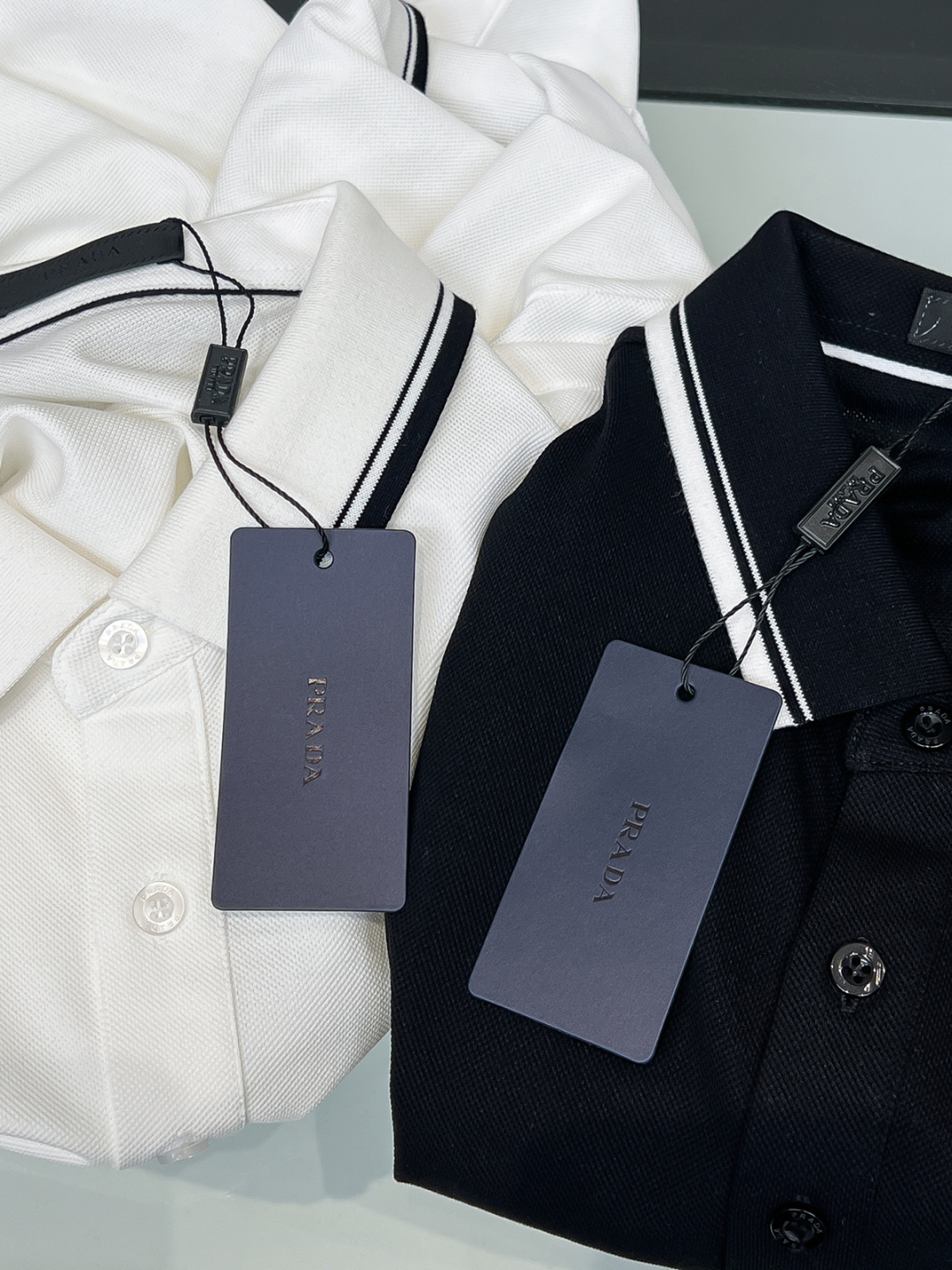 Prada.普拉达 SS26春夏新品经典金属三角形徽标Polo衫，以最简约的形式呈现，体现了休闲雅致风格