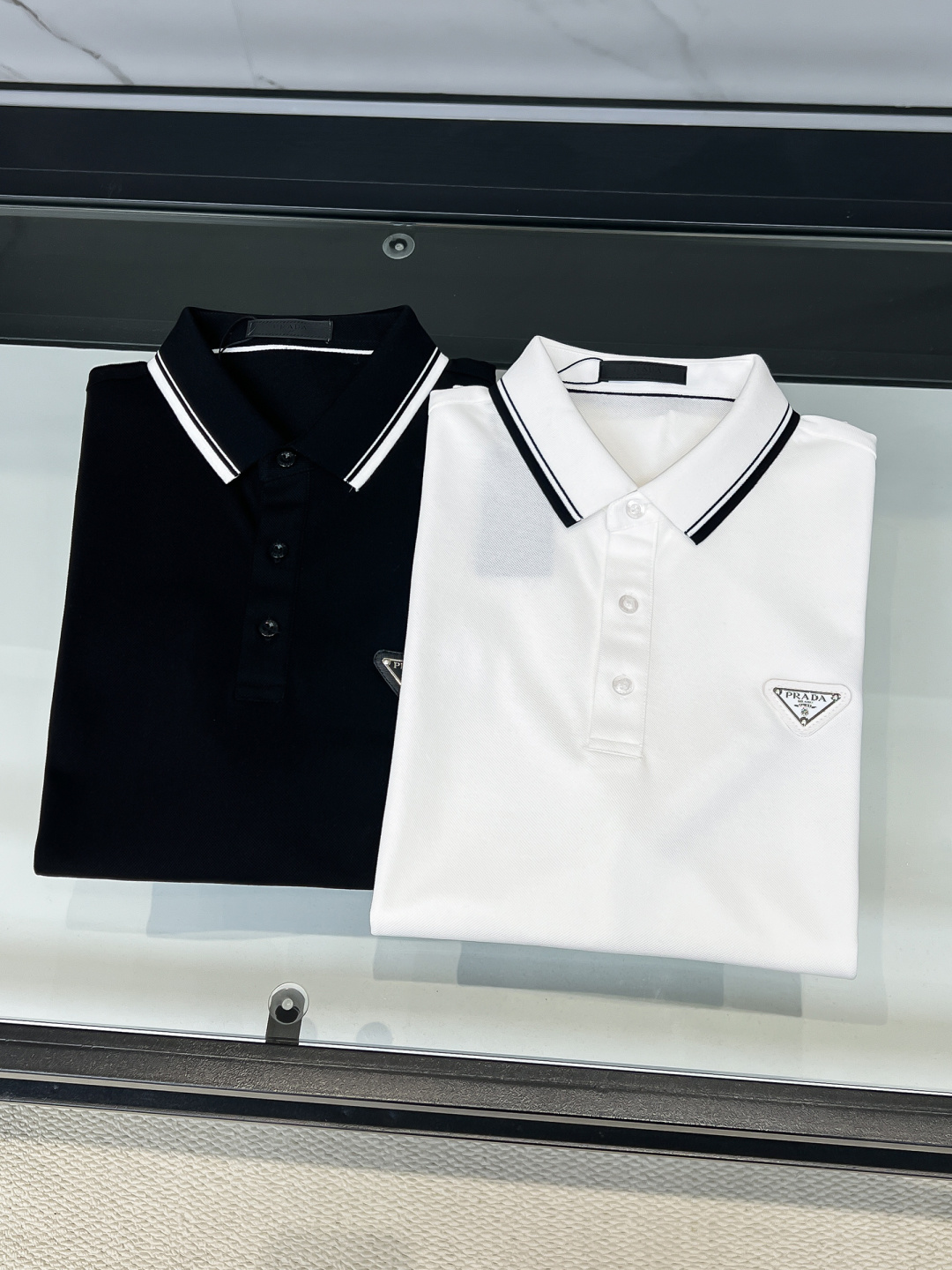 Prada.普拉达 SS26春夏新品经典金属三角形徽标Polo衫，以最简约的形式呈现，体现了休闲雅致风格