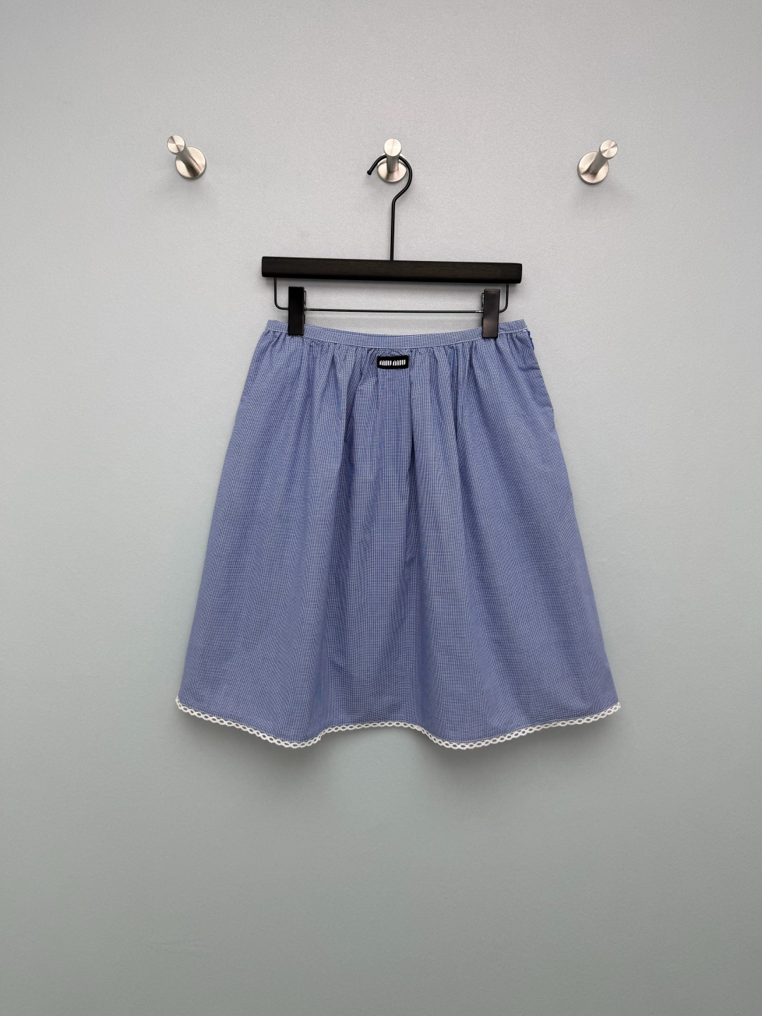 NO:776358,miumi*26 new blue plaid skirt is made of blue and white fine plaid fabric, fresh and retro, with a spring atmosphere  The elastic waist + front pleat design makes the waist more tolerant and does not restrict the waist. At the same time, it makes the skirt more fluffy, covering the hips and making you look slimmer. The A-line short and medium version, with the length near the knees, can not only modify the shape of the legs, but also highlight the light and lively girlish look. There is a small black miu logo in the center of the waist.  , strengthen the brand recognition and enhance the sense of sophistication. The skirt is spliced with white wavy lace, which softens the toughness of the plaid and adds sweetness and tenderness. It is the finishing touch of the whole skirt. The blue and white fine plaid with its own college filter, paired with the white lace on the skirt, directly adds to the sweet girl feeling.  Single color size 3 SML, Miu Miu-clothing, miumiu, skirts,19860909miumi*26新款蓝格纹半身裙 采用蓝白细格纹面料,清新复古,自带春日氛围感 松紧腰+前片褶皱设计,腰部包容性强,不勒腰,同时让裙身更具蓬松感,遮胯显瘦.A字中短款版型,长度在膝盖附近,既能修饰腿型,又能凸显轻盈活泼的少女感.腰头中央带有黑色miu小标章仔,强化品牌辨识度,提升精致感.裙摆拼接白色波浪形蕾丝花边,柔化格纹的硬朗感,增添甜美与温柔感,是整条裙子的点睛之笔.自带学院滤镜的蓝白细格纹,搭配裙摆的白色蕾丝花边,甜妹感直接拉满 单色3码SML,缪缪-服装,miumiu,skirts,,Women's clothing