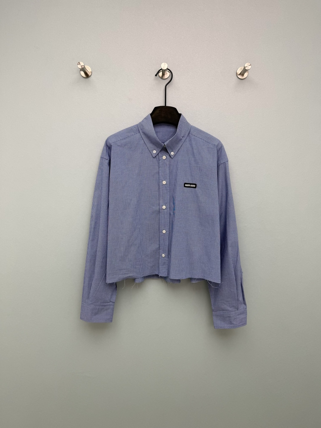 NO:776348,miumi*26 new blue plaid shirt is made of blue and white fine plaid fabric, fresh and retro, with a spring atmosphere. Loose shoulder sleeves + short version, modify the shoulder line, elongate the proportion of the lower body, is friendly to all body types, and can be easily worn by small people.  The raw edge design of the hem is old and casual, adding a sense of laziness and design, which is different from ordinary shirts. The classic pointed collar + button placket, with small collar buttons, retains the formal feel of the shirt and is more refined at the same time. There is a small black miu logo on the chest, which strengthens brand recognition and is an iconic detail of the MIU style~ Monochrome 3-code SML, Miu Miu-clothing, miumiu, shirts,19860909miumi*26新款蓝格纹衬衣 采用蓝白细格纹面料,清新复古,自带春日氛围感 宽松落肩袖+短款版型,修饰肩线,拉长下半身比例,对各种身材都很友好,小个子也能轻松驾驭 下摆毛边设计,做旧随性,增加慵懒感与设计感,区别于普通衬衫.经典尖领+纽扣门襟,搭配小领扣,保留衬衫的正式感,同时更显精致.胸前带有黑色miu小标章仔,强化品牌辨识度,是MIU系风格的标志性细节~ 单色3码SML,缪缪-服装,miumiu,shirts,,Women's clothing