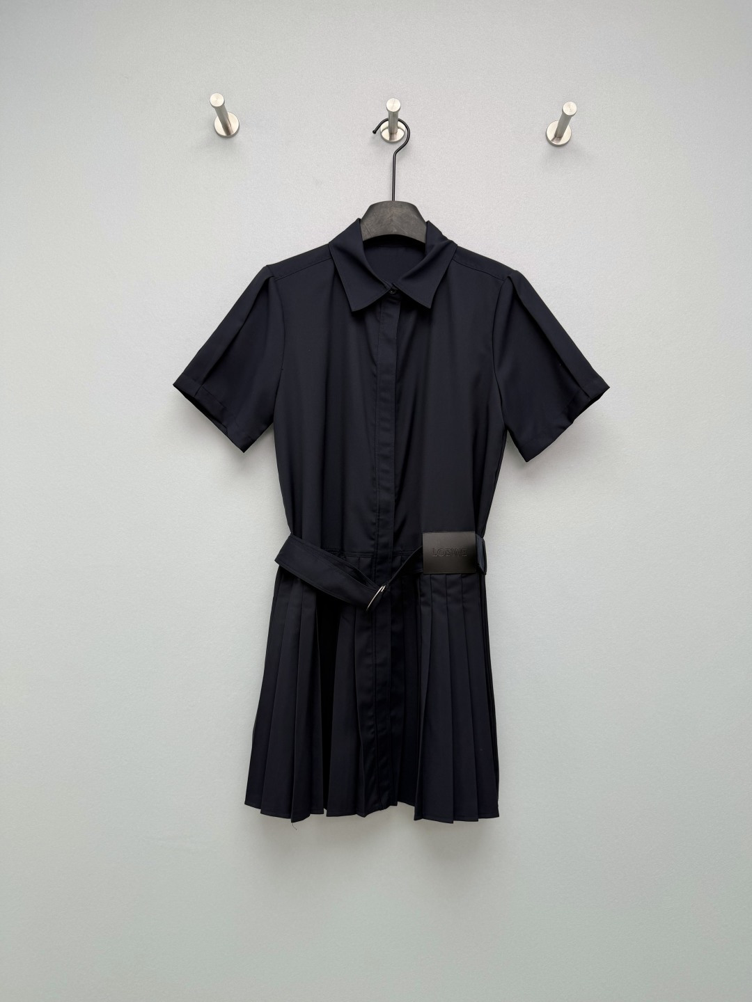 NO:776303,LOEW*26 work style shirt pleated dress  Classic lapel + short sleeve design, single-row hidden buttons on the front, waist with wide belt of the same fabric and metal D-ring buckle, and three-dimensional pleated skirt at the hem, which can effectively modify the waist-to-hip ratio and elongate the leg line. Black leather LOEW* label embossed on the waist side, belt buckle  It is also engraved with the brand name to enhance the recognition of light luxury. The micro-pleat design on the shoulders modifies the shoulder line, the fabric has a good drape feeling, the pleated hem is flexible and elegant when walking, and the leather label enhances the sense of sophistication. The camel color is gentle and retro, and the navy blue is calm and capable, meeting the needs of different styles and occasions~  2 colors and 3 codes SML, Loewe-clothing, loewe, loewe, skirts, shirts, T-shirt,19860909LOEW*26工装风衬衫百褶连衣裙 经典翻领+短袖设计,前襟单排暗扣,腰部配同面料宽腰带与金属D形环扣,下摆为立体百褶裙型,能有效修饰腰臀比例,拉长腿部线条.腰侧压印黑色皮革LOEW*标签,腰带扣环也刻有品牌字样,强化轻奢辨识度.肩部微褶设计修饰肩线,面料垂坠感佳,百褶下摆走路时灵动飘逸,皮革标签提升精致感.驼色温柔复古,藏青沉稳干练,满足不同风格与场合需求~ 2色3码SML,罗意威-服装,loewe,loewe,skirts,shirts,T-shirt,,Women's clothing