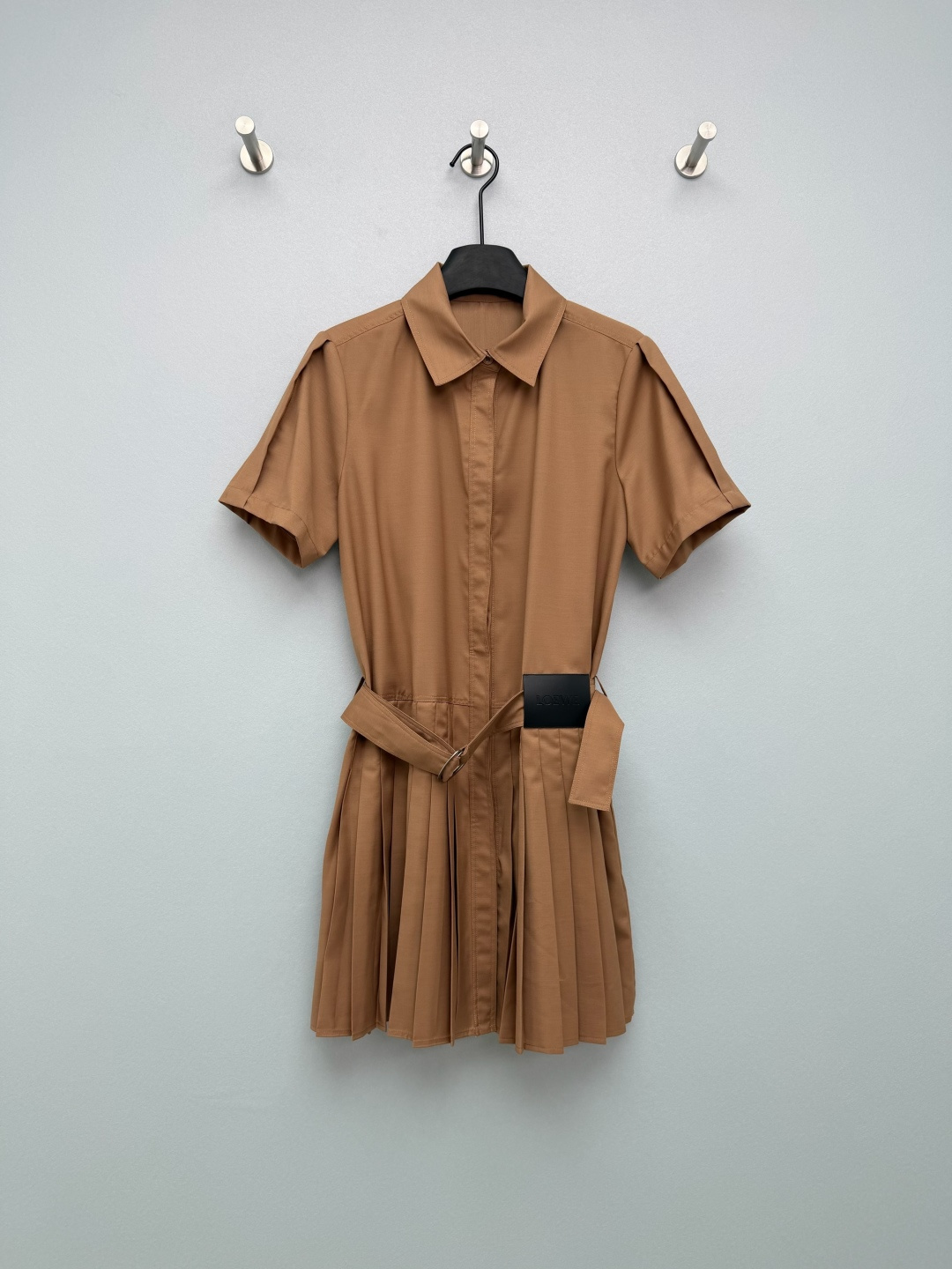 NO:776314,LOEW*26 work style shirt pleated dress  Classic lapel + short sleeve design, single-row hidden buttons on the front, waist with wide belt of the same fabric and metal D-ring buckle, and three-dimensional pleated skirt at the hem, which can effectively modify the waist-to-hip ratio and elongate the leg line. Black leather LOEW* label embossed on the waist side, belt buckle  It is also engraved with the brand name to enhance the recognition of light luxury. The micro-pleat design on the shoulders modifies the shoulder line, the fabric has a good drape feeling, the pleated hem is flexible and elegant when walking, and the leather label enhances the sense of sophistication. The camel color is gentle and retro, and the navy blue is calm and capable, meeting the needs of different styles and occasions~  2 colors and 3 codes SML, Loewe-clothing, loewe, loewe, skirts, shirts, T-shirt,19860909LOEW*26工装风衬衫百褶连衣裙 经典翻领+短袖设计,前襟单排暗扣,腰部配同面料宽腰带与金属D形环扣,下摆为立体百褶裙型,能有效修饰腰臀比例,拉长腿部线条.腰侧压印黑色皮革LOEW*标签,腰带扣环也刻有品牌字样,强化轻奢辨识度.肩部微褶设计修饰肩线,面料垂坠感佳,百褶下摆走路时灵动飘逸,皮革标签提升精致感.驼色温柔复古,藏青沉稳干练,满足不同风格与场合需求~ 2色3码SML,罗意威-服装,loewe,loewe,skirts,shirts,T-shirt,,Women's clothing