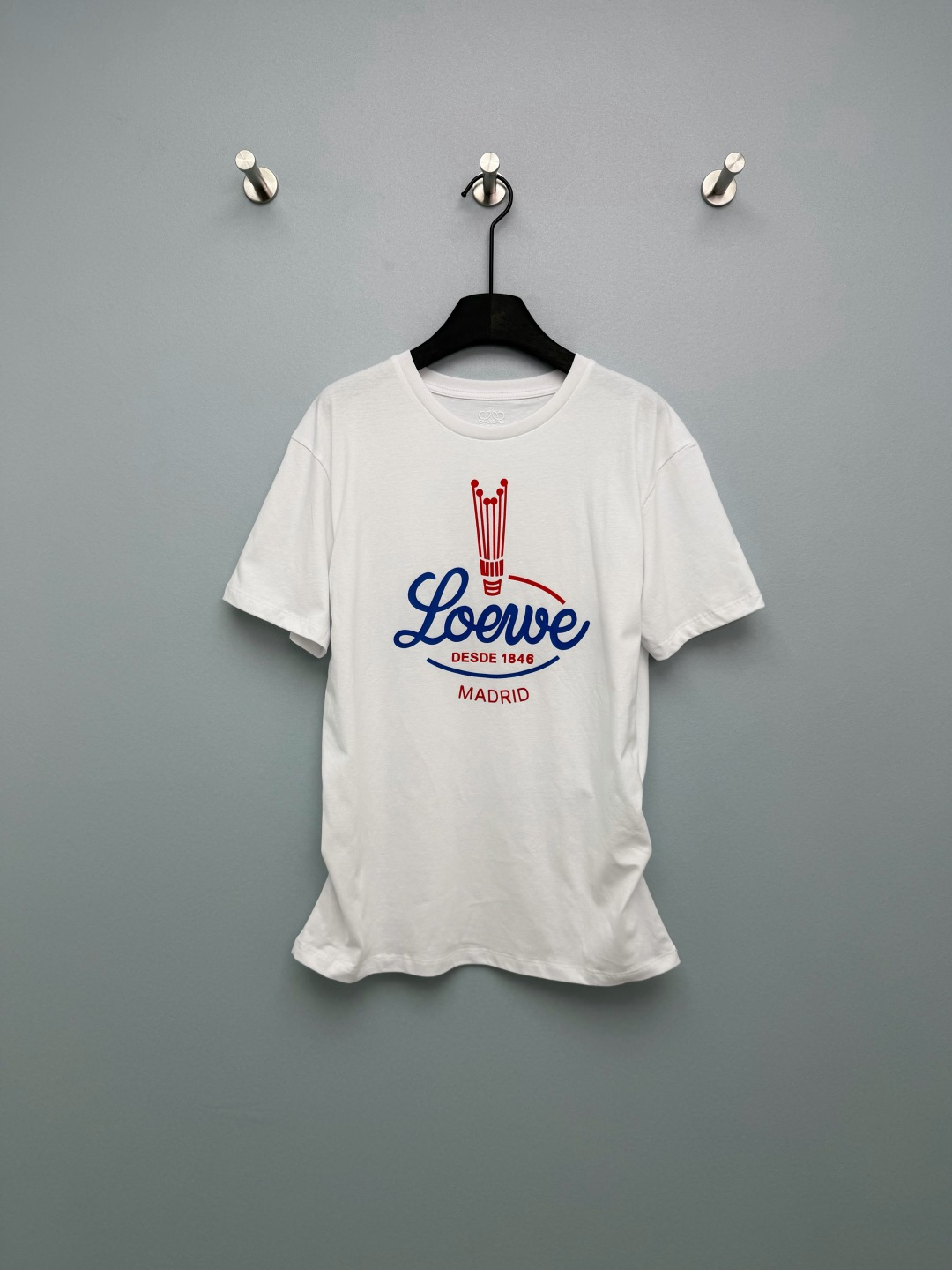 NO:776764,Loew*26 new retro American printed short-sleeved T-shirt. Multiple ways to wear it. Can be worn in a loose regular fit. Contains drawstring buttons that can be buttoned to instantly change into pleated designs on both sides. The red and blue badge print on the chest really gets more and more interesting the more you look at it. The candlestick logo + the handwritten brand name, the details are full of retro accents, 'DESDE'  1846' directly brings out the brand's sense of history. The pure cotton fabric is extremely comfortable, and the loose fit is friendly to all body types. Paired with jeans, it is an American street style. Paired with a skirt, it instantly transforms into a retro lady. You can't go wrong with black and white with your eyes closed!  2 colors and 3 codes SML, Loewe-clothing, loewe, loewe, skirts, jeans, T-shirt, tees, t-shirt,19860909Loew*26新款复古美式印花短袖T恤 多种穿搭方式 可宽松常规版型 内含抽绳纽扣可系扣秒变两侧褶皱设计 胸前的红蓝徽章印花真的越看越有味道,烛台标识+手写体品牌名,细节里全是复古腔调,“DESDE 1846”直接把品牌历史感拉满.纯棉面料巨舒服,宽松版型对各种身材都友好,搭配牛仔裤是美式街头风,配半裙又秒变复古大小姐,黑白两色闭眼入都不会错！2色3码SML,罗意威-服装,loewe,loewe,skirts,jeans,T-shirt,tees，t-shirt,,Women's clothing