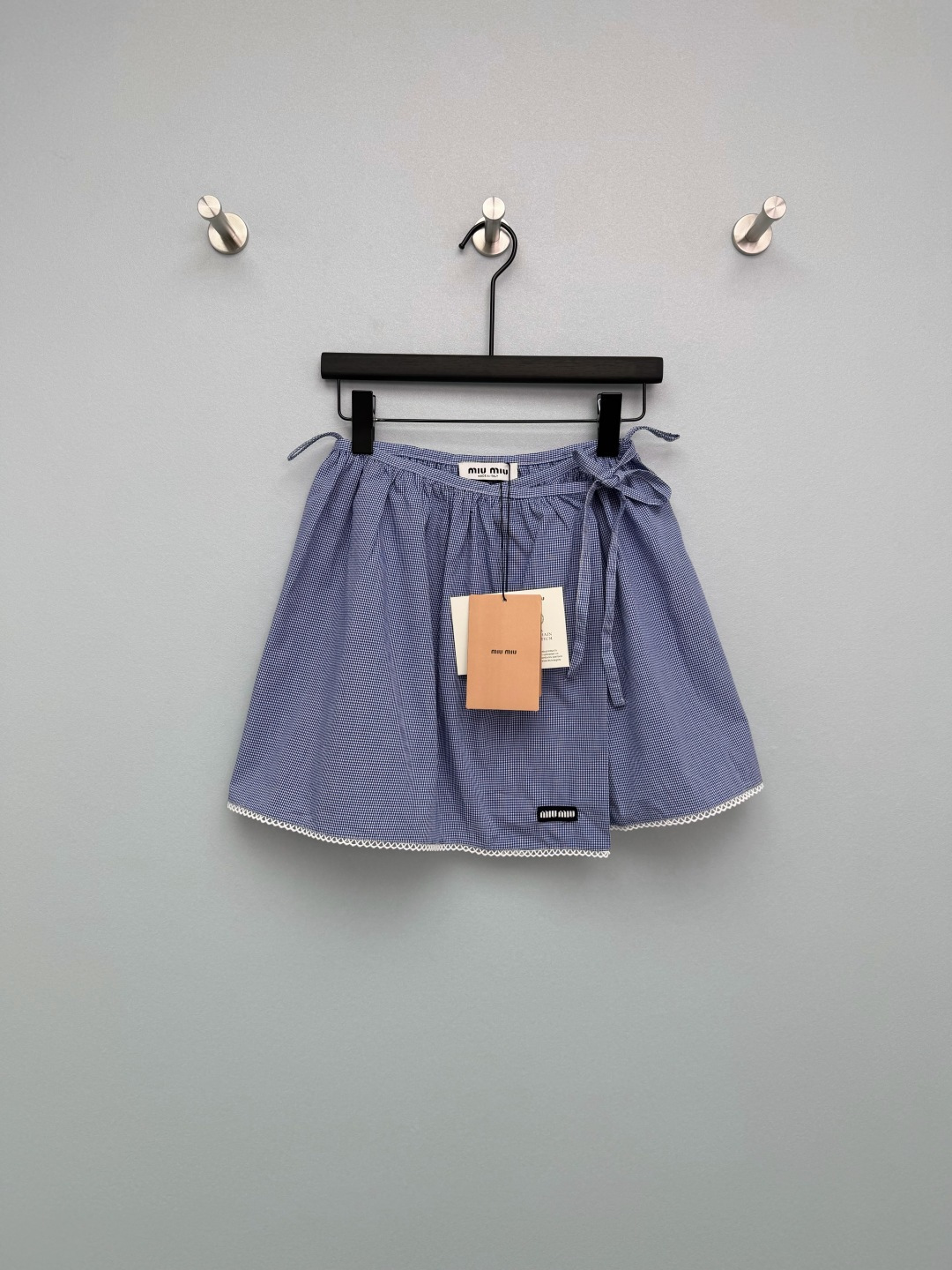 NO:776748,miumi*26 new blue plaid patch design short skirt. Made of blue and white fine plaid fabric, fresh and retro, with a spring atmosphere. Bow tie on the side of the waist + white lace on the hem  The waist is tolerant and makes the skirt more fluffy, covering the hips and making you look slimmer. The A-line short version can not only modify the shape of the legs, but also highlight the light and lively girlish look. There is a small black miu logo in the center of the waist to strengthen the brand recognition and enhance the look.  Sensational. The skirt is spliced with white wavy lace, which softens the toughness of the plaid and adds sweetness and tenderness. It is the finishing touch of the entire skirt. The blue and white fine plaid with its own college filter, paired with the white lace on the skirt, directly adds to the sweet girl feeling.  Single color size 3 SML, Miu Miu-clothing, miumiu, skirts,19860909miumi*26新款蓝格纹搭片设计短裙 采用蓝白细格纹面料,清新复古,自带春日氛围感  腰部侧边系带蝴蝶结+下摆白色蕾丝花边 腰部包容性强,同时让裙身更具蓬松感,遮胯显瘦.A字短款版型,既能修饰腿型,又能凸显轻盈活泼的少女感.腰头中央带有黑色miu小标章仔,强化品牌辨识度,提升精致感.裙摆拼接白色波浪形蕾丝花边,柔化格纹的硬朗感,增添甜美与温柔感,是整条裙子的点睛之笔.自带学院滤镜的蓝白细格纹,搭配裙摆的白色蕾丝花边,甜妹感直接拉满 单色3码SML,缪缪-服装,miumiu,skirts,,Women's clothing