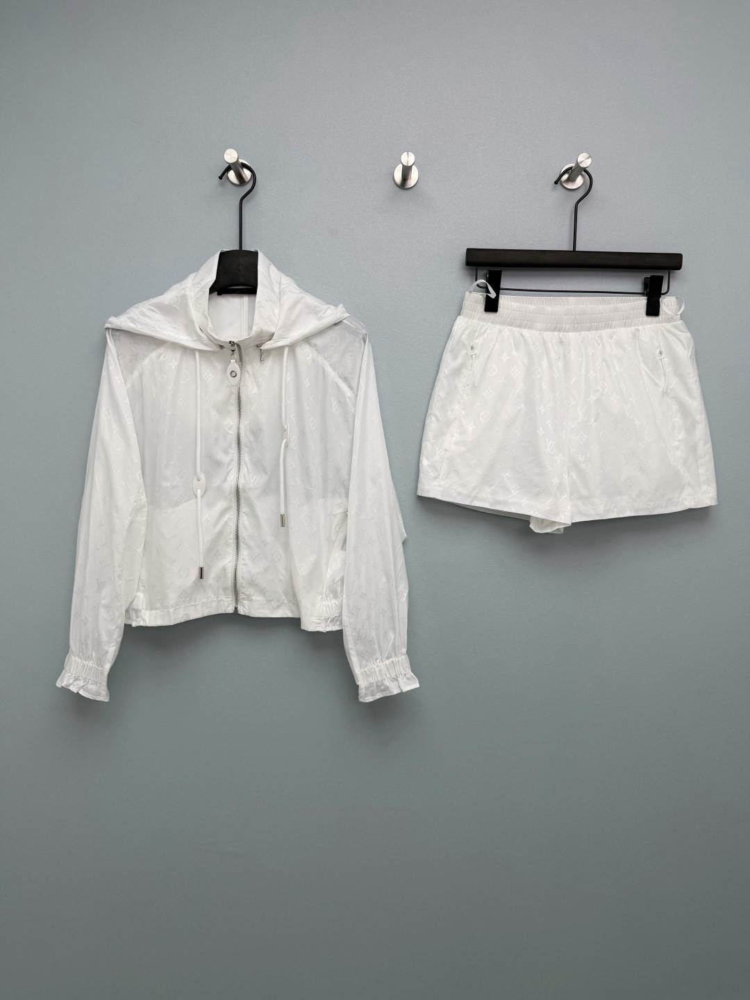 NO:776710,Louis Vuitto*26 new all-print hooded shorts suit, a combination of hooded short jacket + shorts from the same series. The hood is removable and made of light nylon fabric.  The fabric is light and breathable, so it is not stuffy to wear in summer. The classic Monogram is integrated into the fabric texture, showing a delicate luster under the light, which not only retains the brand recognition but avoids exaggeration. The jacket is a short hooded design, with raglan sleeves + elastic cuffs/hem, and a front zipper closure; the shorts are a high-waisted A-line version, with an elastic waist + side zipper pockets, and the length is in the middle of the thigh, visually elongating the proportions of the legs. Who can resist a fairy suit that you don’t have to think about matching when going out?  The black model is cool and slimming, while the white model is clean and refreshing. I want to wear both colors!  2 colors 3 codes SML,Louis Vuitton-clothing,louis vuitton,louis vuitton,shorts,jackets & coats,hats,19860909Louis Vuitto*26新款满印连帽短裤套装 连帽短款外套+同系列短裤的组合 帽子可拆卸 采用轻薄尼龙面料 面料轻薄透气,夏天穿也不闷,经典Monogram融入面料肌理,在光线下呈现细腻光泽感,既保留品牌辨识度又避免浮夸.外套为短款连帽设计,插肩袖+松紧袖口/下摆,前襟拉链开合；短裤为高腰A字版型,松紧腰头+侧拉链口袋,长度在大腿中部,视觉上拉长腿部比例.谁能拒绝一套出门不用想搭配的神仙套装啊！黑色款酷飒又显瘦,白色款干净又清爽,两种颜色都想all in！2色3码SML,路易威登-服装,louis vuitton,louis vuitton,shorts,jackets & coats,hats,,Women's clothing