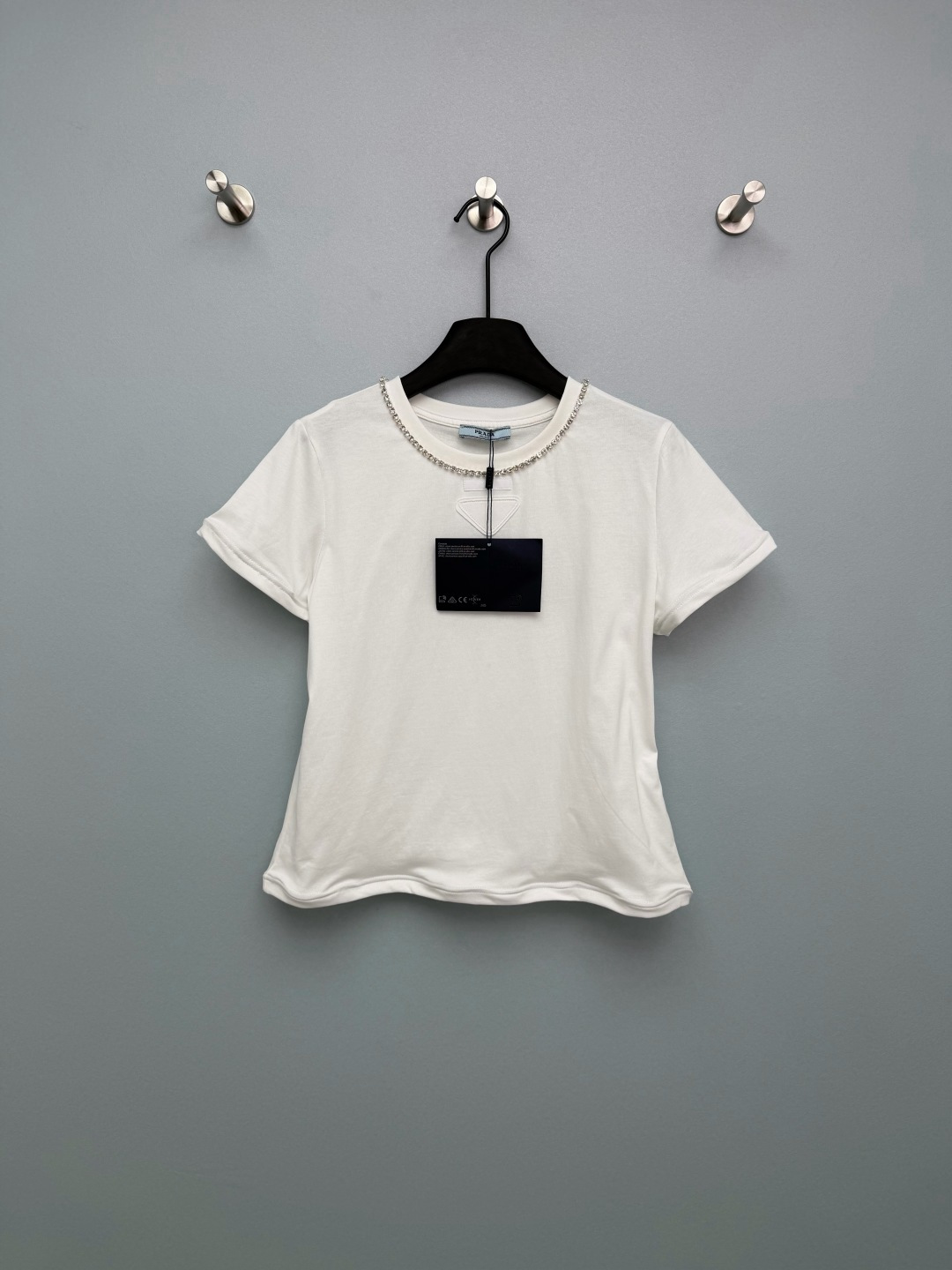 NO:776715,Prad*26 new short-sleeved T-shirt with rhinestone collar. The rhinestones around the neckline are really good!  The blingbling is so sparkly that you can walk with it~ The classic white is clean and refreshing, and the dark coffee color is retro and high-end. I want to all-in both colors. The high-count cotton fabric is soft and skin-friendly, and the small and loose fit is friendly to all body types. The low-key triangle logo + rhinestone details give it a sense of light luxury. You don’t have to worry about matching it when going out, but it is also very stylish. This 'lazy person's exquisite artifact' must be in your spring and summer wardrobe!  2 colors and 3 codes SML, Prada-clothing, prada, prada, T-shirt, tees, t-shirt,19860909Prad*26新款领口水钻短袖T恤 领口一圈水钻真的太会了！blingbling的超闪,走路都带光～ 经典白干净清爽,深咖色复古又高级,两种颜色都想all in 高支棉面料软糯亲肤,小宽松版型对各种身材都很友好 低调的三角标+水钻细节,轻奢感拉满,出门不用费心搭配也很出片 春夏衣柜里必须有这件“懒人精致神器”！2色3码SML,普拉达-服装,prada,prada,T-shirt,tees，t-shirt,,Women's clothing