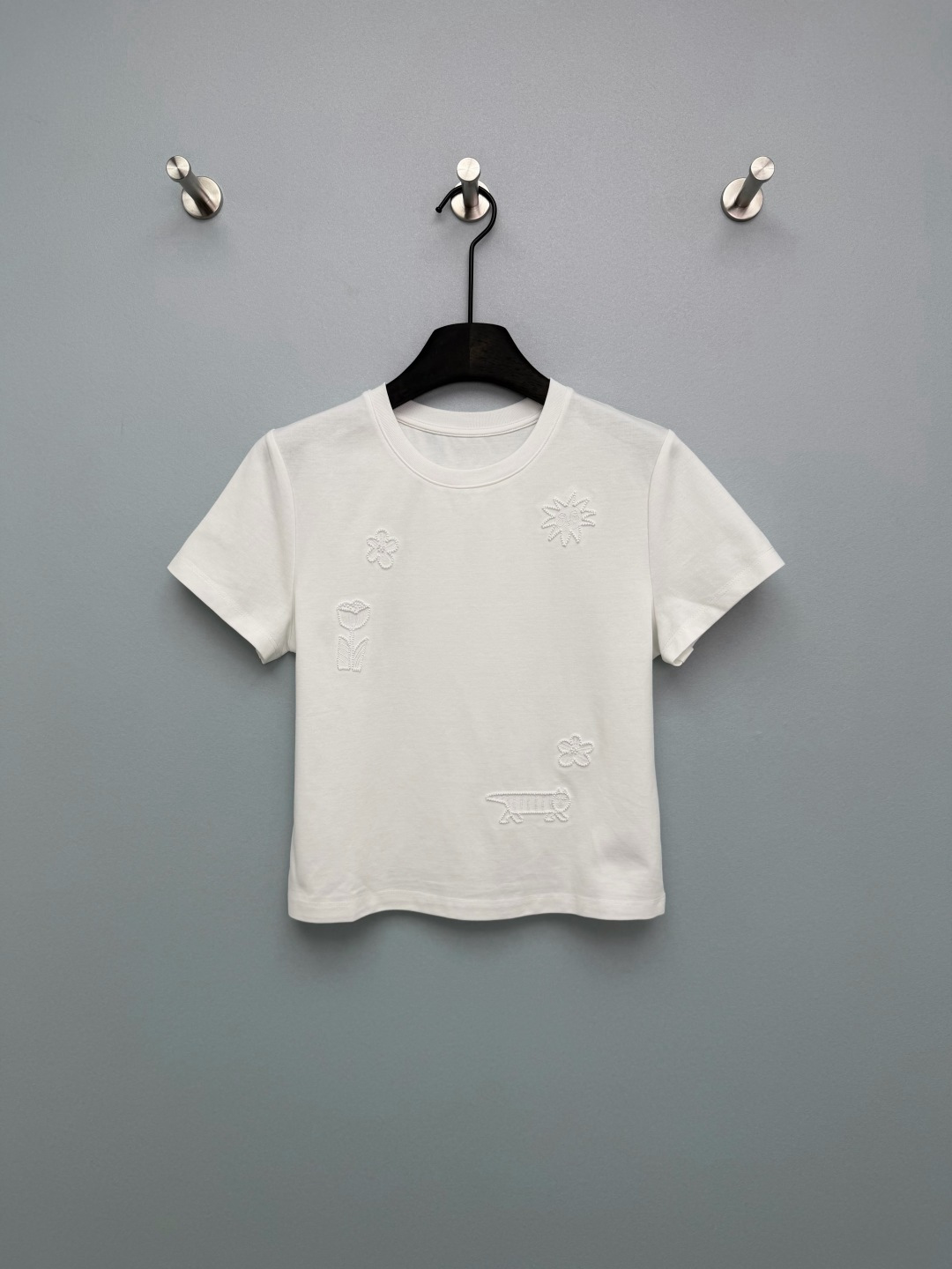 NO:776597,chan*l 26 new childlike embroidered beaded short-sleeved T-shirt. Classic round neck + fitted short cut. It is neat and not tight, can optimize body proportions, and is friendly and tolerant to various body shapes. The front uses three-dimensional embroidery + hand-beading technology, scattered with childlike patterns such as sun smiles, small flowers, tulips, little lions, etc. The embroidery lines are full, and the beading is dotted in the center of the flower, which reflects the shimmer under the light and enhances the sense of sophistication.  The beads are blingbling under the sun, low-key and sparkling, giving you a girly look with a windy look when you walk!  The same color embroidery + hand-made beading, it feels uneven, the texture is amazing, not like the basic model at all. 2 colors and 3 sizes SML, Chanel-clothing, chanel, chanel, T-shirt, tees, t-shirt,19860909chan*l 26新款童趣刺绣钉珠短袖T恤 经典圆领+合身短款剪裁,利落不紧绷,能优化身材比例,对各种身形都有友好包容度.正面采用立体刺绣+手工钉珠工艺,散落分布着太阳笑脸、小花、郁金香、小狮子等童趣图案,刺绣线条饱满,钉珠点缀在花心处,在光线下折射微光,提升精致感 阳光下的钉珠blingbling的,低调又闪,走路都带风的少女感拉满！同色刺绣+手工钉珠,摸起来凹凸有致,质感绝了,完全不像基础款 2色3码SML,香奈儿-服装,chanel,chanel,T-shirt,tees，t-shirt,,Women's clothing