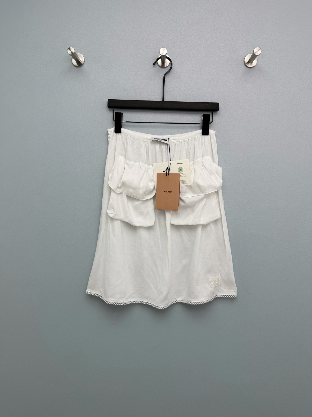 NO:778310,Miu Mi*26 new white large pocket lace skirt. The oversized three-dimensional pockets are really stylish and not monotonous at all. The elastic waist is super friendly to all body shapes. The small belly and hip width are directly invisible. The A-line version perfectly modifies the leg shape, and the pear-shaped body can be worn with eyes closed. The lace details on the skirt are full of details, making it super gentle when walking in the wind. The brand embroidery of the same color is low-key and high-end, you can understand it.  The fabric is light and breathable, so you won’t feel sweaty when wearing it in the summer. It’s refreshing when worn alone, and when paired with a suit, it instantly transforms into a commuting style. Whether paired with the previous Miu white vest, a white shirt, or a T-shirt, you can wear it to create a different feeling. You can have the feeling of a wealthy family, a sweet girl, and a sense of relaxation, all in one!  Miu's girly look will never go out of style~ Monochrome size 3 SML, Miu Miu-clothing, miumiu, skirts, shirts, tees, t-shirt, business suit,19860909Miu Mi*26新款白色大口袋蕾丝边半身裙 超大立体口袋真的太有设计感了,完全不会单调,松紧腰头对各种身材都超友好,小肚腩、胯宽直接隐形 A字版型完美修饰腿型,梨形身材闭眼入 裙摆的蕾丝花边细节感拉满,走路带风都超温柔 同色系品牌刺绣低调又高级,懂的都懂 面料轻薄透气,夏天穿完全不闷汗,单穿清爽,搭配西装又秒变通勤风 不管是配之前的Miu 白背心,还是白衬衫、T恤,都能穿出不一样的感觉 富家千金感、甜妹感、松弛感,一件全拿捏！Miu的少女感真的永远不会过时~ 单色3码SML,缪缪-服装,miumiu,skirts,shirts,tees，t-shirt,business suit,,Women's clothing