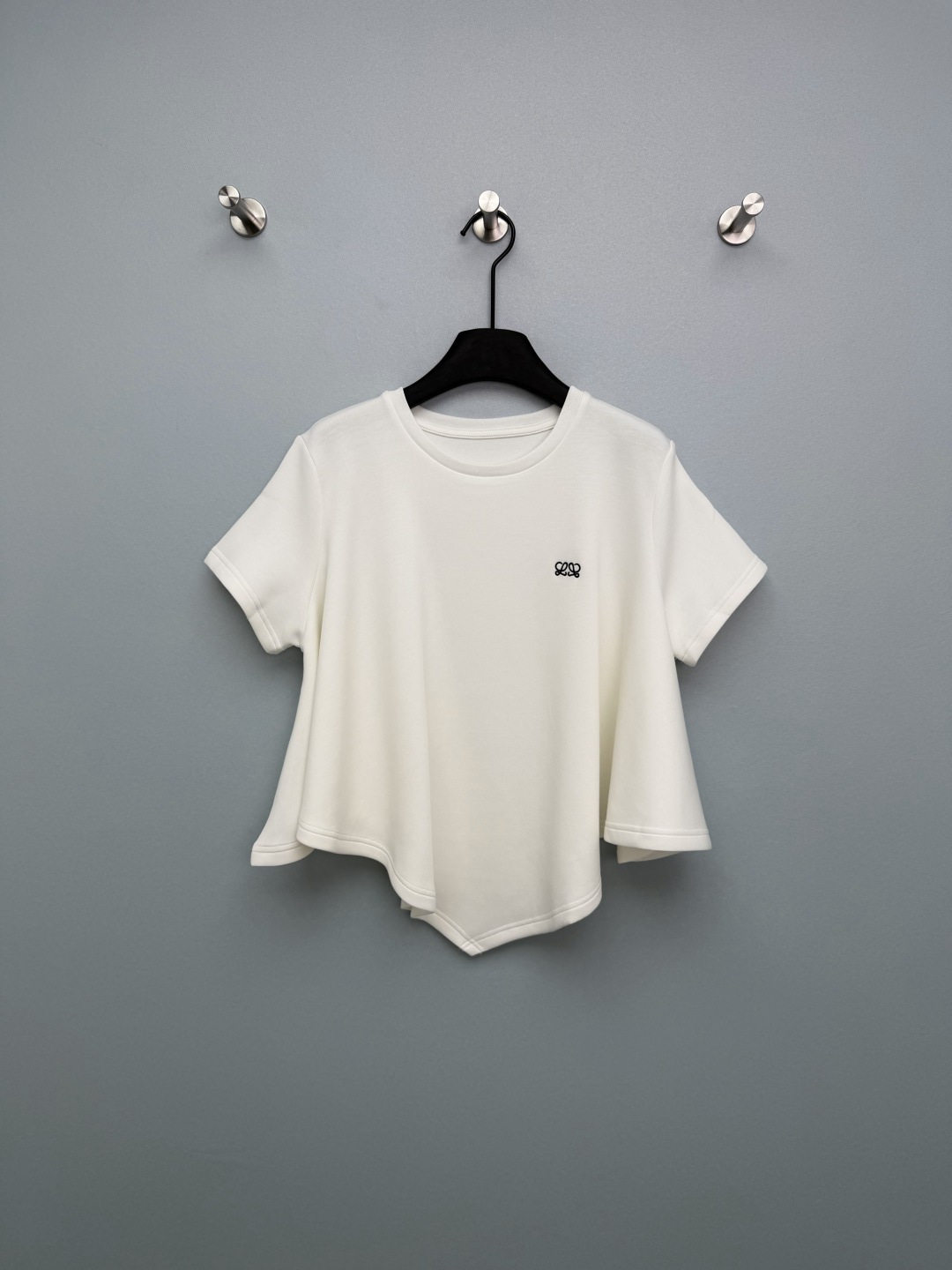 NO:778305,Loew*26 new loose short-sleeved top with irregular hem balances minimalism and sweet coolness just right. The navy blue double L embroidery on the left chest is low-key and dignified, and the details are ecstatic. Loew*’s iconic identification point is the irregular A-line hem, with sharp corners at the front and curved back, hiding the flesh and making you slimmer, and you can change your figure in seconds.  The lines are neatly routed, the collar is ribbed, and the cuffs and hem are overlocked to enhance the texture and make it comfortable to wear without restraint. Pure black is cool, mysterious, and white is slimming and versatile!  2 colors and 3 codes SML, Loewe-clothing, loewe, loewe, T-shirt,19860909Loew*26新款不规则下摆宽松短袖上衣 把极简和甜酷感平衡得刚刚好左胸藏青双L刺绣,低调显贵,细节控狂喜,Loew*标志性识别点 不规则A字下摆,前片尖角+后片弧形,藏肉显瘦,秒变三七分身材 走线工整,领口罗纹包边,袖口与下摆锁边处理,提升质感,穿着舒适无束缚.纯黑色酷飒神秘,白色显瘦百搭 ！2色3码SML,罗意威-服装,loewe,loewe,T-shirt,,Women's clothing