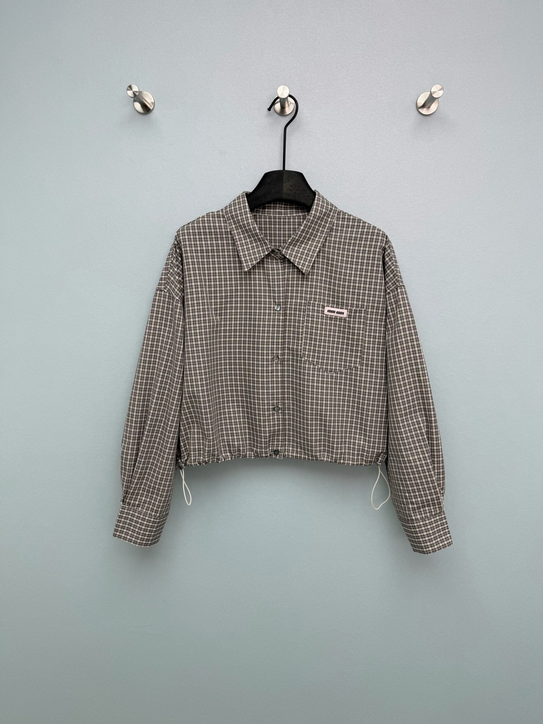 NO:780305,Miu Mi*26 new hem plaid drawstring short shirt. The short drawstring hem directly raises the waistline, making your legs longer in seconds. The lantern sleeve design covers the flesh and looks slimmer. It is friendly to all body types!  The Miu woven label on the left chest is low-key and noble, full of details, and the retro plaid is really college-like!  Whether worn alone, layered under a layer, or opened as a jacket, it’s perfect for commuting, dating, or going out on the street!  It captures the sweet and cool style, academic feel, and relaxed feeling. Wearing it will make you look like a walking retro pictorial!  Single color size 3 SML, Miumiu-clothing, miumiu, jackets & coats, shirts,19860909Miu Mi*26新款下摆格纹抽绳短款衬衫 短款抽绳下摆直接拉高腰线,秒变大长腿,灯笼袖设计遮肉显瘦,对各种身材都友好！左胸的Miu织标低调又显贵,细节感拉满,复古格纹真的太有学院感了！ 不管是单穿、内搭还是敞开做外套都超绝,通勤、约会、出街全hold住！甜酷风、学院感、松弛感全被它拿捏了,穿上就是行走的复古画报！单色3码SML,缪缪-服装,miumiu,jackets & coats,shirts,,Women's clothing
