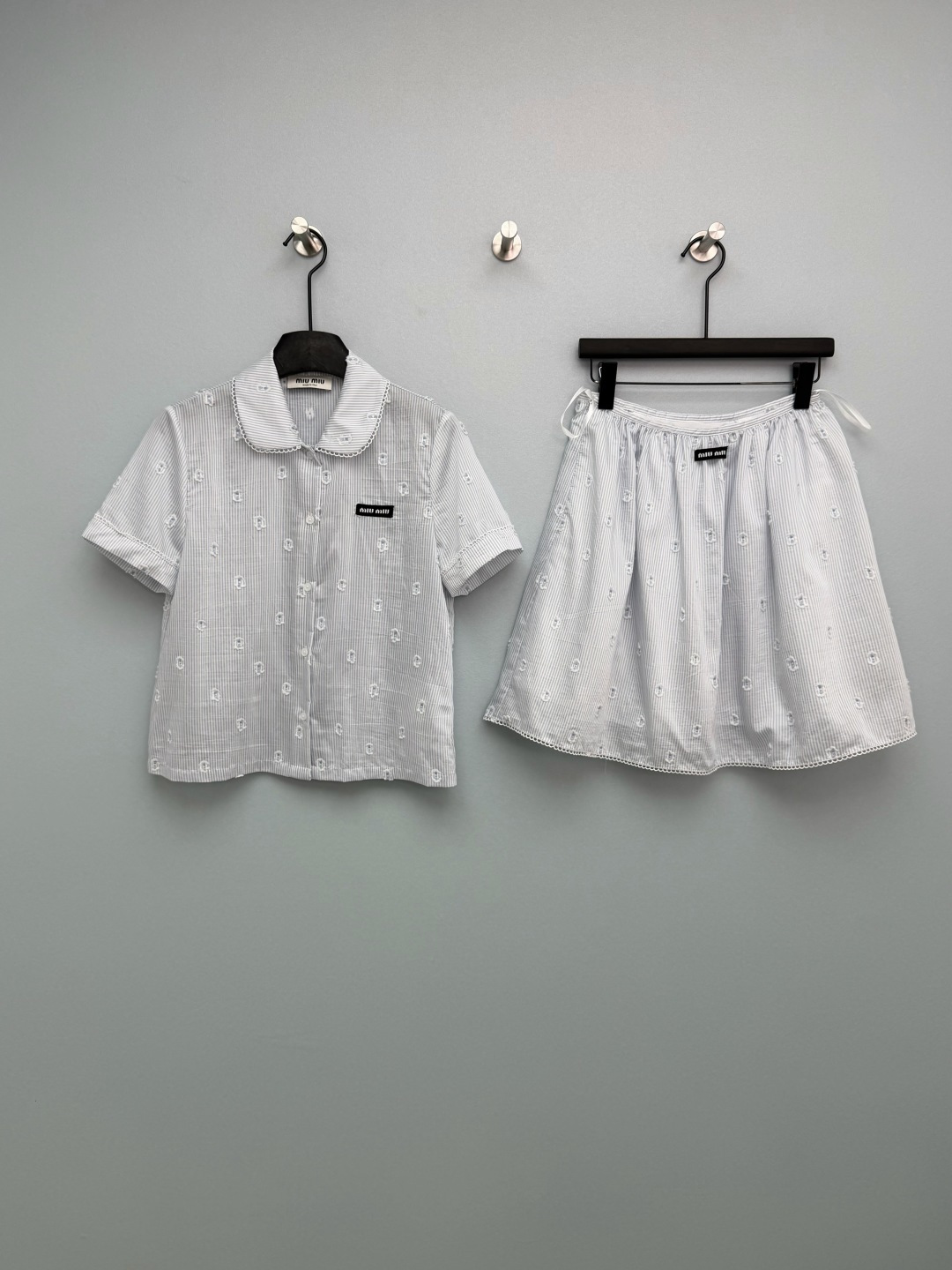 NO:780188,Miu Mi*26's new blue and white striped embroidered shirt + skirt suit has a classic doll collar design, with exquisite hollow lace on the collar and cuffs, which is sweet and stylish; it is fully printed with blue and white pinstripes + M letter three-dimensional jacquard, and is embellished with a black woven logo on the chest, which makes it more recognizable; the short version optimizes body proportions and makes you appear taller and slimmer.  The A-line crotch-shaped skirt covers the crotch and hides the flesh, visually elongating the legs; the skirt is made of the same series of lace, echoing the shirt design, and the whole set is full; the waistband is woven with a logo, which is full of details. It perfectly restores the girly DNA of the brand, and the upper body is like a wealthy daughter~ Monochrome size 3 SML, Miu Miu-clothing, miumiu, skirts, shirts,19860909Miu Mi*26新款蓝白条纹刺绣衬衫+短裙套装 经典娃娃领设计,领边、袖口做精致镂空蕾丝花边,甜美元气；满印蓝白细条纹+M字母立体提花,胸前点缀黑色织唛logo标,辨识度拉满；短款版型,优化身材比例,显高显瘦. 半裙A字花苞裤型,遮胯藏肉,视觉拉长腿型；裙边做同系列蕾丝花边,呼应衬衫设计,整套感拉满；腰头织唛logo标,细节感十足.完美还原品牌少女感DNA,上身就是富家千金既视感~ 单色3码SML,缪缪-服装,miumiu,skirts,shirts,,Women's clothing