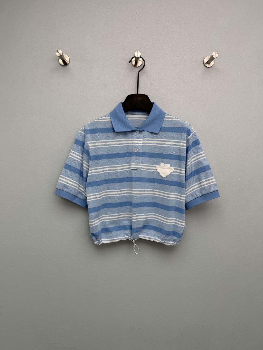 NO:780092,Prad*26 new blue and white striped short-sleeved Polo shirt with gradient stripes of foggy blue and off-white, soft and not picky, with a spring atmosphere, retro and white. The white inverted triangle logo on the left chest is the classic identification symbol of Prad*, low-key highlighting the brand identity and enhancing the sense of luxury of the item. The classic Polo collar design is the same color lapel + placket button, and the drawstring at the hem is neat and stylish, which can not only modify the neck line, but also retain the casual feeling of the Polo shirt~  Pink and white stripes are a perfect choice for spring!  Single color size 3 SML, Prada-clothing, prada, prada, T-shirt,19860909Prad*26新款蓝白条纹短袖Polo衫 雾蓝+米白的渐变条纹,色调柔和不挑皮,自带春日氛围感,复古又显白. 左胸处的白色倒三角徽标,是Prad*的经典识别符号,低调彰显品牌身份,提升单品高级感.经典Polo领设计同色系翻领+门襟纽扣,下摆抽绳 利落有型,既能修饰颈部线条,又保留了Polo衫的休闲感~ 粉白条纹真是春天绝佳首选！单色3码SML,普拉达-服装,prada,prada,T-shirt,,Women's clothing