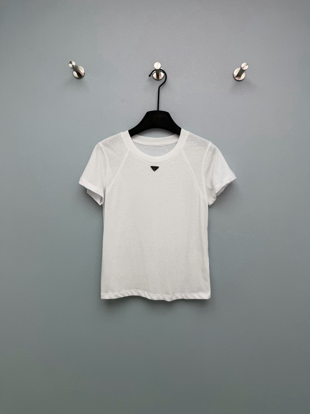 NO:780025,prad*26 new triangle logo raglan T-shirt has a slim fit and short design, which can easily control the fat on the waist and abdomen, and optimize the body proportions; the raglan sleeves perfectly modify the shoulder line, and sisters with slippery and wide shoulders will be ecstatic!  Pair it with high-waisted jeans for a casual and casual style, and with a skirt it instantly becomes a gentle commuter style. Even a small person can wear it to have long legs. The triangular metal logo on the chest is really eye-catching!  The sense of light luxury is instantly enhanced, and you are no longer afraid of clashing styles. The fabric is made of fine cotton material, soft and skin-friendly, breathable and not sweaty in summer ~ 2 colors and 3 sizes SML, Prada-clothing, prada, prada, skirts, jeans, tees, t-shirt,19860909prad*26新款三角标插肩T恤 修身短款设计,轻松收住腰腹赘肉,优化身材比例；插肩袖完美修饰肩线,溜肩、宽肩姐妹直接狂喜！搭高腰牛仔裤是元气休闲风,配半身裙秒变温柔通勤风,小个子也能穿出大长腿.胸前的三角金属标真的太点睛了！轻奢感瞬间提升,再也不怕撞款.面料是细腻的棉感材质,柔软亲肤,夏天穿透气不闷汗~ 2色3码SML,普拉达-服装,prada,prada,skirts,jeans,tees，t-shirt,,Women's clothing