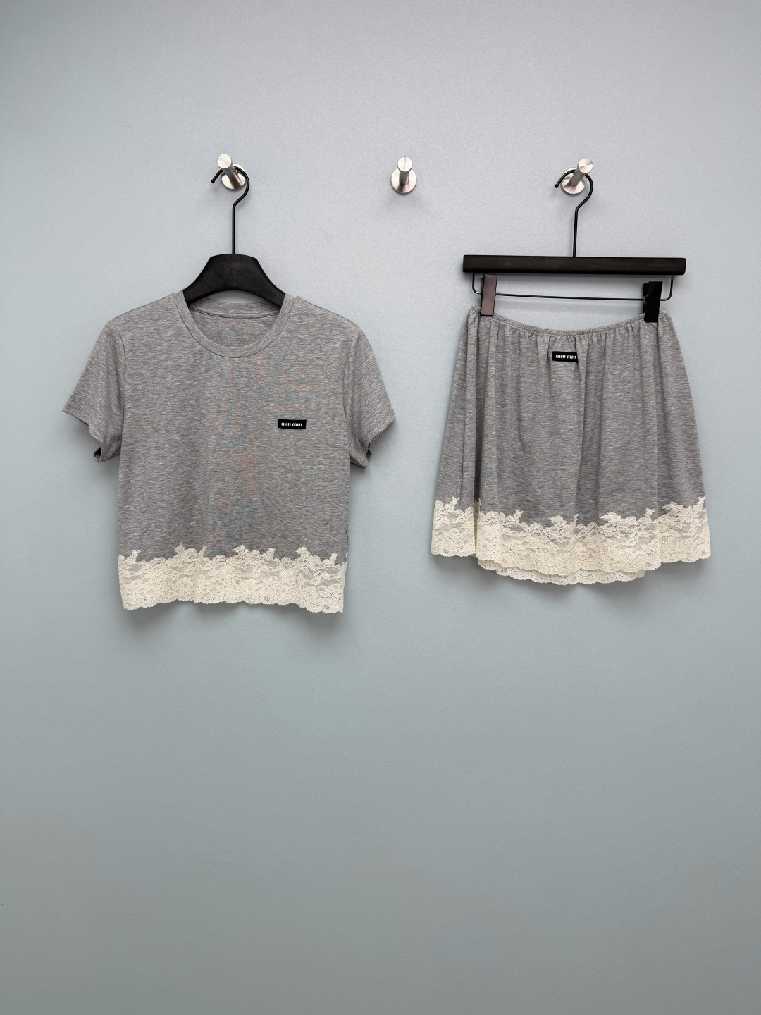 NO:781672,Miu Mi*26 new gray lace splicing suit is a combination of T-shirt and short skirt. The top and the hem of the shorts are spliced with off-white lace, which softens the monotony of the gray basic model and creates a 'pure, sweet and spicy' visual effect. It is a highly recognizable design element at the moment. The chest of the top and the waist of the shorts are equipped with a black Miu style woven label. The gray modal fabric is soft and comfortable to wear, and it is not sweaty at all in summer.  The white lace splicing at the hem is really the finishing touch, gentle and sexy, filling the sweet and spicy atmosphere. The short top + elastic waist shorts, the shape is huge, the high waistline also shows the long legs. Miu girls close their eyes and enter!  Single color size 3 SMLB, Miu Miu-clothing, miumiu, skirts, shorts, tees, t-shirt,19860909Miu Mi*26新款格雷灰蕾丝拼接套装 T恤短裙的组合 上衣与短裤下摆均拼接米白色蕾丝花边,柔化了灰色基础款的单调感,打造出“纯欲甜辣”的视觉效果,是当下极具辨识度的设计元素.上衣胸口与短裤腰头均配有黑色Miu风格织标 灰色莫代尔面料软乎乎的,贴身穿巨舒服,夏天完全不闷汗 下摆的白色蕾丝拼接真的点睛之笔,温柔又性感,甜辣氛围感拉满 短款上衣+松紧腰短裤,版型巨藏肉,高腰线还显腿长 miu系女孩闭眼入！单色3码SMLB,缪缪-服装,miumiu,skirts,shorts,tees，t-shirt,,Women's clothing
