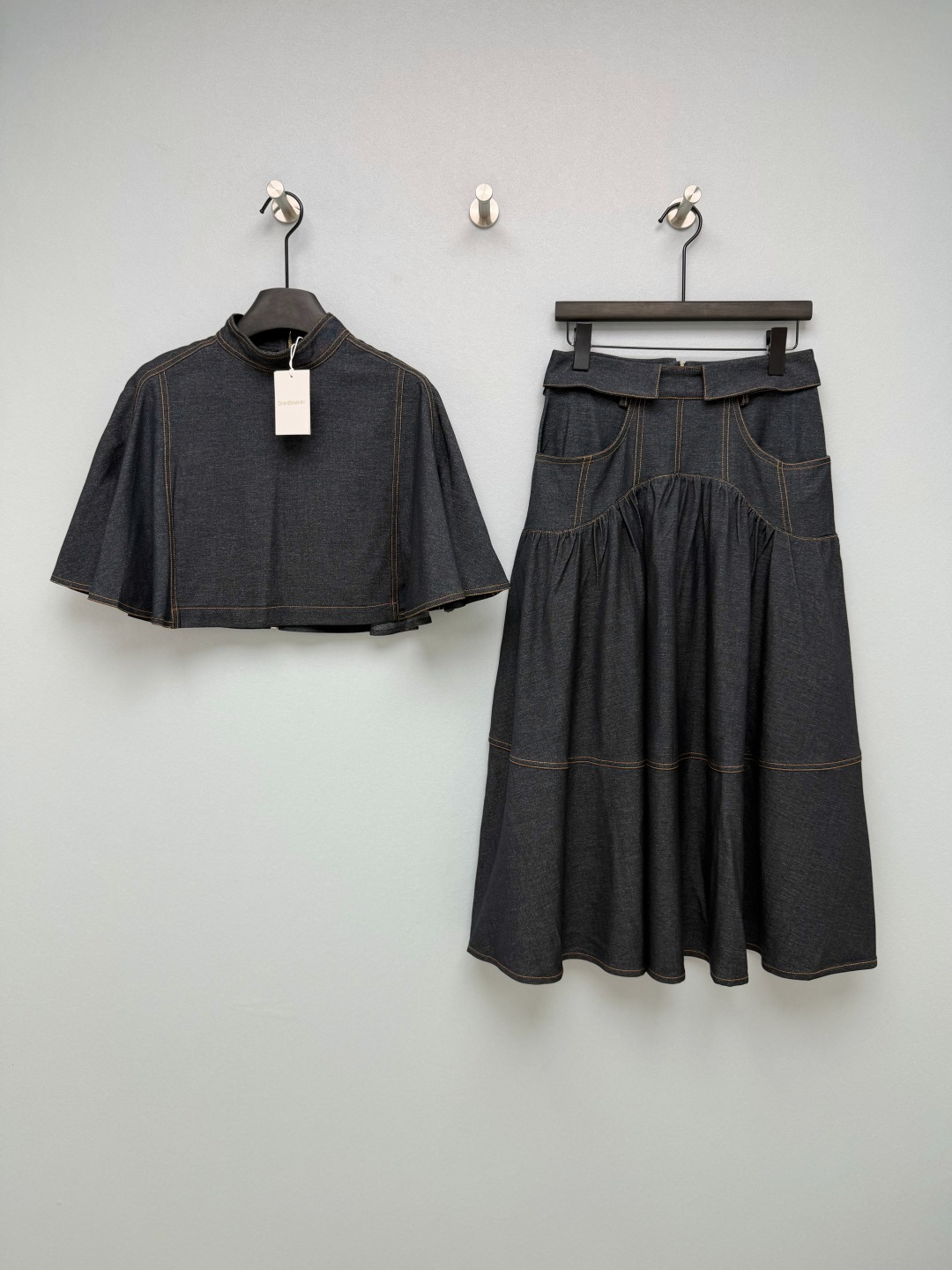 NO:783528,ZIMMERMAN*26 new retro denim suit, a combination of cape top and skirt. Dark indigo denim base color + contrasting stitching, classic retro and exquisite; the fabric has a strong drape, is not easy to wrinkle, and has a full texture. The stand collar + cape style short design breaks the dullness of conventional denim items and brings an elegant aura; the short version optimizes body proportions, raises the waistline, making you look taller and slimmer; the zipper on the back makes it easy to put on and take off.  The skirt is high-waisted and spliced into an A-line shape. The upper part is designed with darts and pockets to fit the waist and abdomen lines; the waist cuff design adds a sense of detail, and the crotch is spliced and shirred to optimize the crotch line and is friendly to pear-shaped figures; the mid-length A-line skirt modifies the leg shape and has an elegant drape when walking. It has both retro elegance and a capable aura!  Solid color size 4 SMLXL, Zimmerman-clothing, skirts,19860909ZIMMERMAN*26新款复古牛仔套装 斗篷上衣半裙的组合 深靛蓝牛仔底色+撞色车线,经典复古又显精致；面料垂坠感强,不易起皱,质感拉满.上衣立领+斗篷式短款设计,打破常规牛仔单品的沉闷,自带优雅气场；短款版型优化身材比例,拉高腰线,显高显瘦；背后拉链开合,穿脱方便. 半裙高腰拼接A字版型,上半部分采用收省与口袋设计,贴合腰腹线条；腰部翻边设计增加细节感,胯部拼接抽褶工艺,优化胯部线条,对梨形身材友好；中长A字裙摆修饰腿型,行走时自带优雅垂坠感.兼具复古优雅与干练气场！单色4码SMLXL,兹默曼-服装,skirts,,Women's clothing