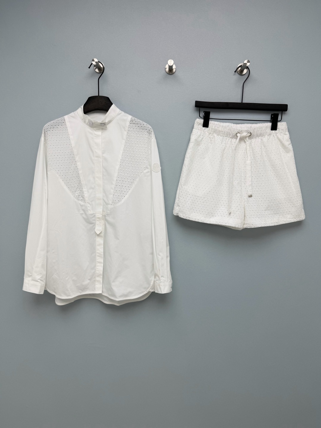 NO:784446,Top details Moncle*26 new white hollow casual suit  The shirt adopts a stand-up collar + concealed placket design, and the shoulders are spliced with mesh hollow fabric, which is breathable and not sweaty. The cuffs are embroidered with the Moncle* logo, which is low-key and full of recognition. The shorts are made of the same series of hollow fabrics, with an elastic drawstring waist and an A-line shape.  The crotch is decorated, and the trousers are slightly cinched, taking into account both comfort and neatness. The sides are also embroidered with the brand logo. This white hollow suit is so beautiful that it makes my heart melt. The whole is a refreshing white that has a breathable feeling. It is not picky at all, even sisters with yellow skin can close their eyes and wear it!  Single color size 3 SMLJ, mask-clothing, Moncler, shorts, shirts,19860909上衣细节Moncle*26新款 白色镂空休闲套装  衬衫采用立领+暗门襟设计,肩部拼接网眼镂空面料,透气不闷汗,袖口带有Moncle*刺绣徽标,低调识别度拉满.短裤采用同系列镂空面料,松紧抽绳腰头,A字版型修饰胯部,裤脚微收口设计,兼顾舒适与利落感,侧边同样带有品牌徽标刺绣.这套白色镂空套装真的美到我心巴上整体是自带呼吸感的清爽白,完全不挑皮,黄皮姐妹也能闭眼入！单色3码SMLJ,蒙口-服装,Moncler,shorts,shirts,,Women's clothing