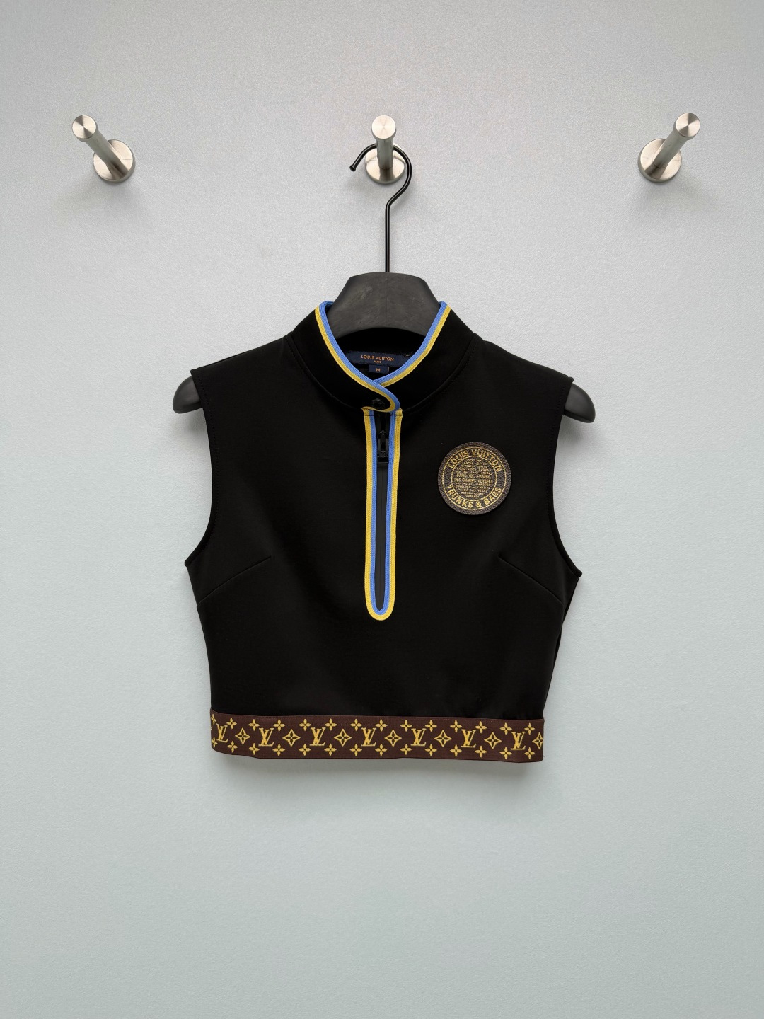 NO:821003,Louis Vuitto*26 new stand-up collar sleeveless vest top with iconic Monogram pattern on the waist and chest 'TRUNKS &  BAGS' round badge, with customized brand zippers and buttons, is instantly recognizable, and low-key highlights the luxury brand texture. The blue and yellow contrasting edges outline the neckline and placket, breaking the black dullness and bringing a retro sports atmosphere; the half-open zipper design has both a sense of design and the convenience of putting on and taking off. The short waist-exposed sleeveless design, neat waist + three-dimensional tailoring, optimized shoulder and neck lines, easily create right-angled shoulders and high waistlines, super high degree of matching. Excited to control the details!  Customized zippers + badge embroidery perfectly combine the high-end sense of luxury brands with the vitality of sports style, a must-have for spring and summer wardrobes!  Solid color size 3 SML,Louis Vuitton-clothing,louis vuitton,louis vuitton,19860909Louis Vuitto*26新款立领无袖马甲上衣标志性Monogram老花腰边、胸口“TRUNKS & BAGS”圆形徽章,搭配定制品牌拉链与纽扣,辨识度直接拉满,低调彰显奢牌质感.蓝黄撞色包边勾勒领口与门襟,打破黑色沉闷感,自带复古运动氛围；半开拉链设计兼具设计感与穿脱便利性.短款露腰无袖设计,利落收腰+立体剪裁,优化肩颈线条,轻松打造直角肩与高腰线,搭配度超高.细节控狂喜！定制拉链+徽章刺绣,把奢牌的高级感和运动风的活力完美融合,春夏衣柜必备！单色3码SML,路易威登-服装,louis vuitton,louis vuitton,,Women's clothing