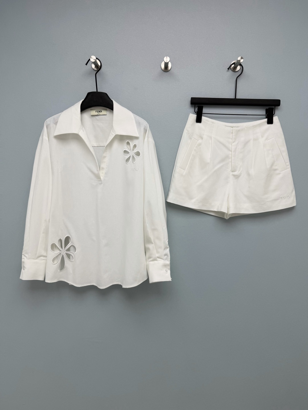 NO:821462,FEND*26 new floral hollow suit, long-sleeved top and shorts combination  The shirt adopts a V-shaped lapel + dropped shoulders and a loose fit, which is neat and slim. It is matched with the embroidered logo of the same brand and shows the texture in a low-key manner. The high-waisted straight shorts are very friendly to the pear-shaped body. The pleated design on the front panel modifies the crotch line and elongates the proportion of the legs, making it look 'leggy' instantly. The hollow flower embroidery on the shirt is the soul of the whole look, and the edges of the petals are outlined with embroidery thread of the same color. It is exquisite and advanced, breaking the dullness of the basic style, and brings a sense of breathability and design!  2 colors and 3 codes SML, Fendi-clothing, fendi, fendi, shorts, shirts,19860909FEND*26新款花卉镂空套装 长袖上衣短裤的组合 衬衫采用V字翻领+落肩宽松版型,利落显瘦,搭配同品牌刺绣标识,低调彰显质感.高腰直筒短裤对梨形身材超友好,前片打褶设计修饰胯部线条,拉长腿部比例,秒变“腿精”.衬衫上的镂空花朵刺绣是整套look的灵魂,花瓣边缘用同色系绣线勾勒,精致又高级,打破了基础款的沉闷,自带呼吸感和设计感！2色3码SML,芬迪-服装,fendi,fendi,shorts,shirts,,Women's clothing