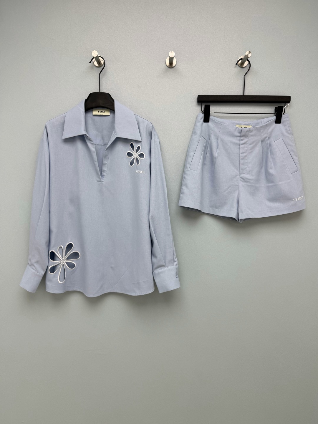 NO:821474,FEND*26 new floral hollow suit, long-sleeved top and shorts combination  The shirt adopts a V-shaped lapel + dropped shoulders and a loose fit, which is neat and slim. It is matched with the embroidered logo of the same brand and shows the texture in a low-key manner. The high-waisted straight shorts are very friendly to the pear-shaped body. The pleated design on the front panel modifies the crotch line and elongates the proportion of the legs, making it look 'leggy' instantly. The hollow flower embroidery on the shirt is the soul of the whole look, and the edges of the petals are outlined with embroidery thread of the same color. It is exquisite and advanced, breaking the dullness of the basic style, and brings a sense of breathability and design!  2 colors and 3 codes SML, Fendi-clothing, fendi, fendi, shorts, shirts,19860909FEND*26新款花卉镂空套装 长袖上衣短裤的组合 衬衫采用V字翻领+落肩宽松版型,利落显瘦,搭配同品牌刺绣标识,低调彰显质感.高腰直筒短裤对梨形身材超友好,前片打褶设计修饰胯部线条,拉长腿部比例,秒变“腿精”.衬衫上的镂空花朵刺绣是整套look的灵魂,花瓣边缘用同色系绣线勾勒,精致又高级,打破了基础款的沉闷,自带呼吸感和设计感！2色3码SML,芬迪-服装,fendi,fendi,shorts,shirts,,Women's clothing