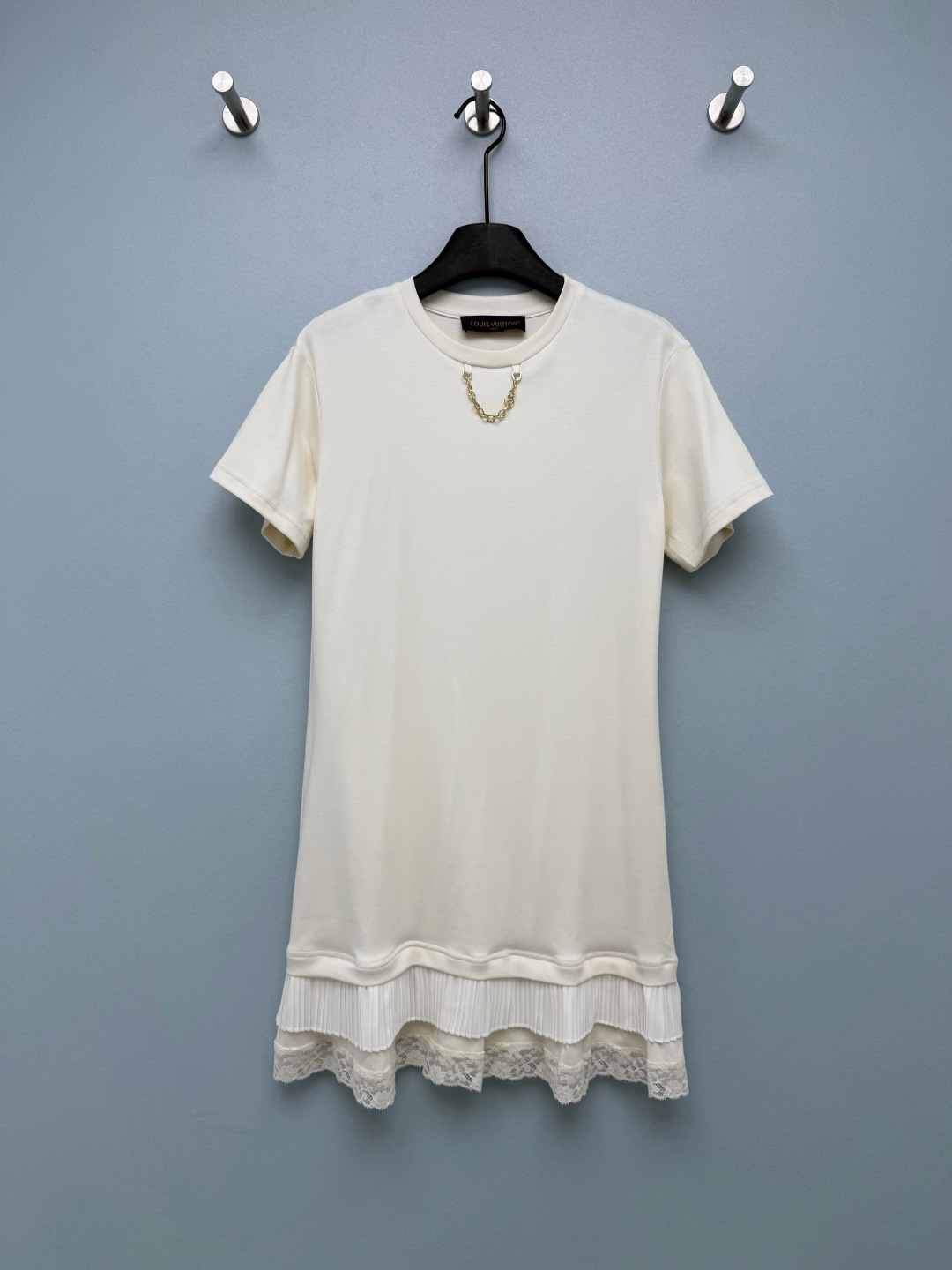 NO:821498,Louis Vuitto*26 new metal chain short-sleeved T-shirt dress with collar. The leather embossed triangle mark on the collar chain cuffs shows the brand identity in a low-key manner. The details are full of luxurious texture, saying goodbye to the monotony of ordinary T-shirt dresses. The hem is made of three-layer splicing of 'T-shirt fabric + pleated chiffon + lace', breaking the dullness of the basic style. It has a light and agile girlish feel, making it more elegant when walking. The loose straight version is friendly to all body types.  Both black and white are stunning, the white is gentle and age-reducing, and the black is cool and versatile. It can be worn alone or paired with a denim jacket. It is perfect for lazy people in summer!  2 colors and 3 codes SML, Louis Vuitton-clothing, louis vuitton, louis vuitton, skirts, jackets & coats, T-shirt, tees, t-shirt,19860909Louis Vuitto*26新款领口的金属链条短袖T恤裙 领口链条袖口的皮质压花三角标低调彰显品牌身份,细节处尽显奢华质感,告别普通T恤裙的单调感 下摆采用“T恤面料+百褶雪纺+蕾丝花边”三层拼接,打破基础款的沉闷,自带轻盈灵动的少女感,走动时更显飘逸.宽松直筒版型,对各种身材都很友好, 黑白两色都超绝,白色温柔减龄,黑色酷飒百搭,单穿或搭配牛仔外套都超有范儿,夏天的懒人穿搭被它承包了！2色3码SML,路易威登-服装,louis vuitton,louis vuitton,skirts,jackets & coats,T-shirt,tees，t-shirt,,Women's clothing
