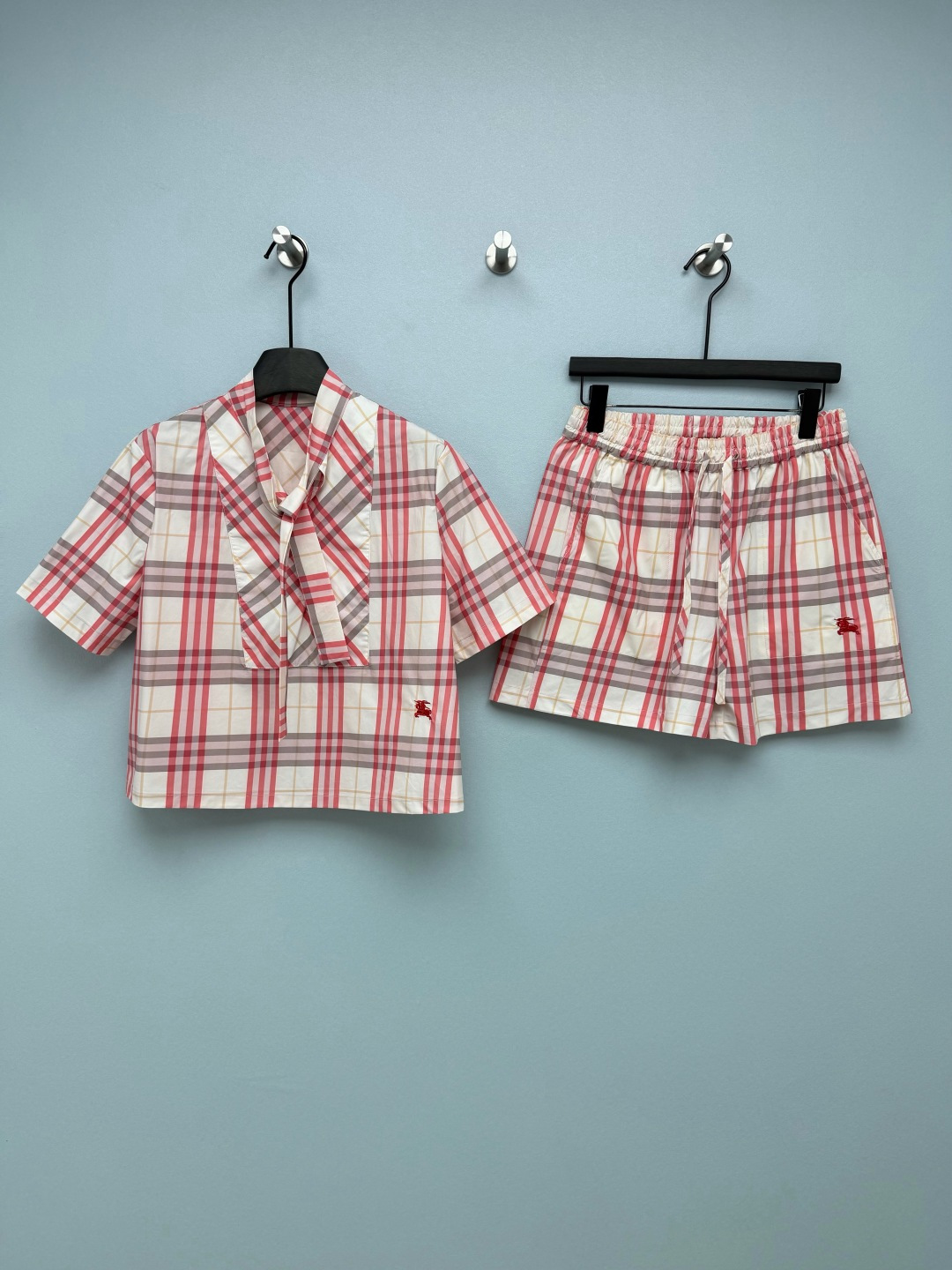 NO:821525,Burberr*26 new plaid suit, a combination of collared streamer short-sleeved top and shorts, uses the brand's signature plaid pattern, with milky white as the base, and low-saturation pink and gray lines, weakening the mature feel of the traditional plaid pattern. It comes with a spring soft light filter, and yellow leather can be easily controlled. The red equestrian knight logo embroidery on the body is neat and full, low-key and highlights the brand texture. The ribbon design on the top also irritates me!  Tie it up to look like a good girl, untie it and you will look cool and cool in seconds, you can wear it twice in one outfit and it is very cost-effective!  The elastic waist of the shorts is also very friendly to chubby girls. It hides the flesh and makes the legs straight. Just wear it with white shoes and you will be full of energy. The classic plaid is actually made into such a gentle milky white + pink tone. It comes with a soft light filter. When you wear it, you will look like a walking spring pictorial. Monochrome size 3 SML, Burberry-clothing, burberry, shorts, T-shirt,19860909Burberr*26新款格子套装 领口飘带短袖上衣短裤的组合 采用品牌标志性格纹,以奶白为基底,搭配低饱和粉、灰线条,弱化了传统格纹的成熟感,自带春日柔光滤镜,黄皮也能轻松驾驭.衣身的红色马术骑士徽标刺绣,走线工整饱满,低调又能凸显品牌质感.上衣的飘带设计也太戳我了！系上是乖乖女,解开秒变酷辣风,一衣两穿性价比拉满！ 短裤的松紧腰对肉肉女孩也超友好,藏肉又显腿直,随便搭个小白鞋就元气满满 经典格纹居然被做成了这么温柔的奶白+粉调,自带柔光滤镜,穿上就是行走的春日画报 单色3码SML,博柏利-服装,burberry,shorts,T-shirt,,Women's clothing