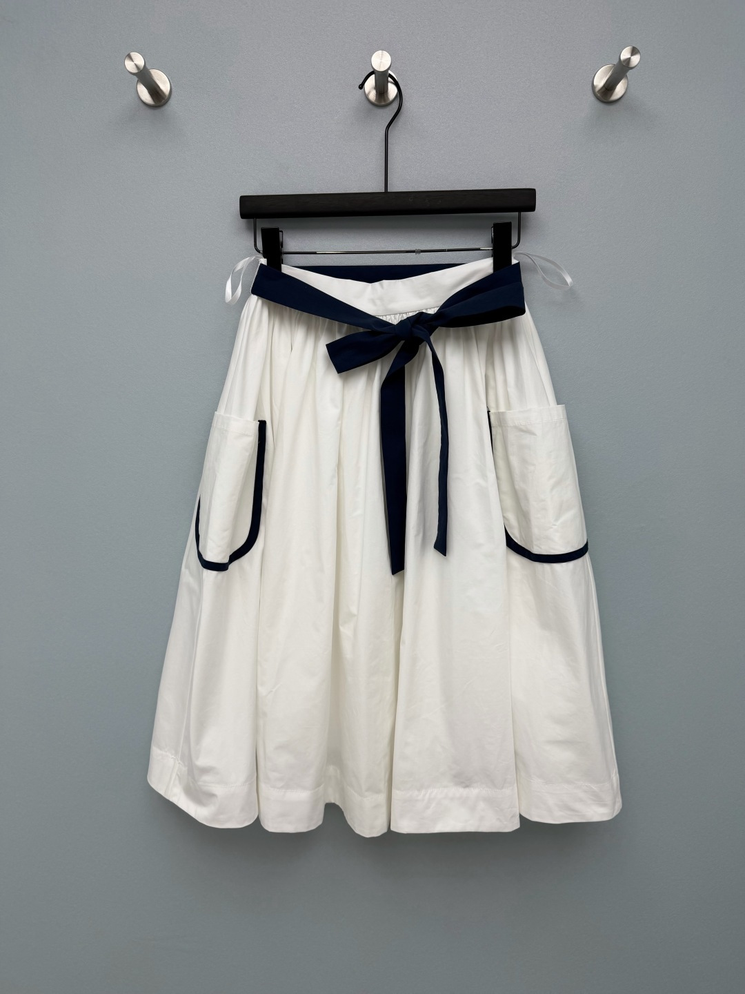 NO:822439,Prad*26 new navy-style skirt has a retro college feel with classic white and blue contrasting colors. It comes with a French college filter. It looks good with any outfit. The high waist + A-line silhouette. A wide navy belt at the waist instantly creates a slim waist. The A-line skirt perfectly hides the crotch and thigh flesh, and the pear-shaped figure looks great with closed eyes!  The length of the mid-length model just reaches the middle of the calf, which looks taller and covers the flesh, and can be easily controlled by small people. The large contrasting pockets on both sides with hidden small logos are too annoying for me!  It is practical and has a sense of design, which instantly separates it from ordinary white skirts. The fabric is crisp and breathable cotton. It is not sweaty at all when worn in summer. It has a great drape feeling and has a smart temperament when walking around!  Single color size 3 SML,Prada-clothing,prada,prada,skirts,19860909Prad*26新款海军风半身裙 复古学院感拿捏经典的白蓝撞色,自带法式学院滤镜,随便搭都好看高腰+A字廓形,腰头的藏青宽腰带一系,瞬间掐出小蛮腰,A字裙摆完美藏住胯部和大腿肉肉,梨形身材闭眼冲！ 中长款长度刚好到小腿中部,显高又遮肉,小个子也能轻松驾驭.两侧的撞色大口袋暗藏小logo也太戳我了吧！既实用又有设计感,和普通白裙瞬间拉开差距.面料是挺括又透气的棉质,夏天穿完全不闷汗,垂坠感绝了,走动间自带灵动气质！单色3码SML,普拉达-服装,prada,prada,skirts,,Women's clothing