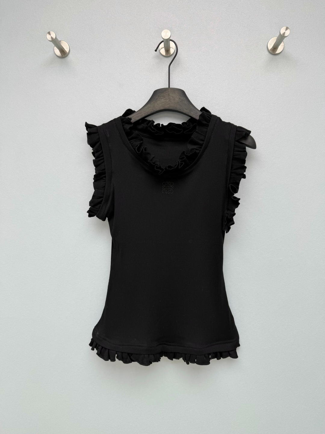 NO:822396,LOEW*26 new ruffled vest with gentle ceiling!  Whoever wears it, it comes with a French gentle filter, which looks good when worn alone. The black and white color directly covers the entire spring and summer outfit. The waist-cinching version + double-layered ruffles, the fungus details on the neckline, armholes and hem add a sense of gentleness. It can also quietly modify the shoulder and neck lines. Sisters with slippery and wide shoulders can also wear right-angled shoulders. The slim-fitting but not tight version fits the body shape without constricting the flesh, easily outlines the waistline, and has a great slimming effect!  The low-key LOEWE embroidered logo on the thin chest is exquisite and unobtrusive, instantly improving the overall texture and making it different from ordinary vests. The fabric is soft and stretchy rib knitting, which is skin-friendly and breathable. It is not sweaty at all when worn in summer. It is full of elasticity and is not easy to deform after long-term wear. 2 colors and 3 sizes SML, Loewe-Clothing, loewe, loewe,19860909LOEW*26新款荷叶边背心 温柔天花板！谁穿谁甜自带法式温柔滤镜,单穿内搭都好看,黑白双色直接承包整个春夏的穿搭收腰版型+双层荷叶边,领口、袖笼和下摆的木耳边细节,把温柔感拉满,还能悄悄修饰肩颈线条,溜肩、宽肩姐妹也能穿出直角肩既视感.修身但不紧身的版型,贴合身形又不勒肉,轻松勾勒腰线,显瘦效果绝了！细胸前低调的LOEWE刺绣logo,精致又不张扬,瞬间提升整体质感,和普通背心拉开差距. 面料是软糯又有弹力的罗纹针织,亲肤透气,夏天穿也完全不闷汗,弹力十足,久穿也不易变形 2色3码SML,罗意威-服装,loewe,loewe,,Women's clothing