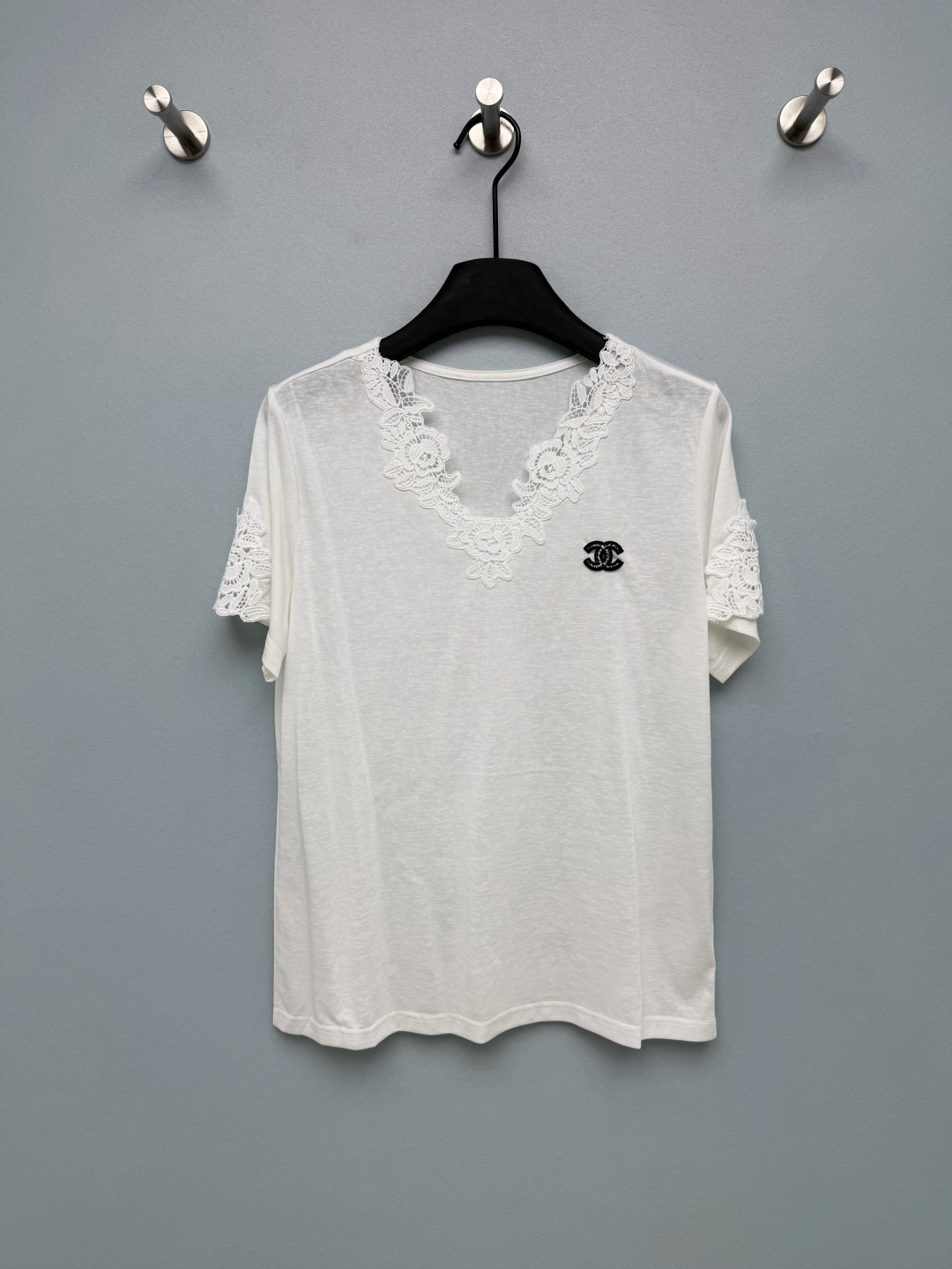 NO:822880,chan*l 26 new short-sleeved t-shirt tops  The edge of the V-neck and the cuffs are spliced with flower lace of the same color, which brings a gentle atmosphere. It also modifies the neck line and weakens the shoulder width, which is friendly to various face and shoulder shapes. The lace uses exquisite floral embroidery technology, with full details and not cheap. The black and white color combinations present two styles of pure lust and elegance respectively. Left chest  The double C embroidered logo is the finishing touch, low-key and recognizable, which strengthens the brand texture. The overall style is simple and neat, without unnecessary design, which can highlight the details of the lace and logo. It is made of light and breathable fabric with a soft mist texture. The upper body is skin-friendly and comfortable, making it refreshing and not stuffy to wear in spring and summer.  2 colors and 3 codes SMLR, Chanel-clothing, chanel, chanel, T-shirt, tees, t-shirt,19860909chan*l 26新款短袖t恤上衣 V领边缘与袖口采用同色系花朵蕾丝拼接,自带温柔氛围感,同时修饰颈部线条,弱化肩宽,对各种脸型和肩型都很友好.蕾丝采用精致的花卉刺绣工艺,细节饱满不廉价,黑白配色分别呈现出纯欲与优雅两种风格.左胸的双C刺绣logo是点睛之笔,低调又有辨识度,强化了品牌质感.整体版型简约利落,没有多余的设计,更能突出蕾丝与logo的细节亮点.采用轻薄透气的面料,自带柔雾质感,上身亲肤舒适,春夏穿着清爽不闷热 2色3码SMLR,香奈儿-服装,chanel,chanel,T-shirt,tees，t-shirt,,Women's clothing