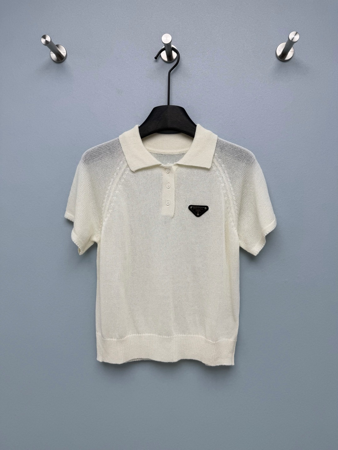 NO:822894,PRAD*26's new knitted Polo short-sleeved top has a simple and high-end feel. It is a versatile item for spring and summer commuting and daily wear!  The classic triangle mark on the left chest is the finishing touch. The metallic logo is exquisite and recognizable, and is the brand's iconic design element. The classic Polo collar + half-button design has a neat and capable temperament, and it can easily be worn with a simple and high-end feel. It is made of breathable mesh knitted fabric, with its own texture and coolness, the upper body is refreshing and not stuffy, and it is super comfortable to wear in spring and summer. Milky white is gentle, light gray is intellectual, and black is slimming!  3 colors and 3 sizes SMLR, Prada-clothing, prada, prada, T-shirt,19860909PRAD*26新款针织Polo短袖上衣 自带简约高级感,是春夏通勤与日常穿搭的百搭单品！左胸的经典三角标是点睛之笔,金属质感的logo牌精致又有辨识度,是品牌标志性的设计元素.经典Polo领+半开襟纽扣设计,自带利落干练的气质,轻松穿出简约高级感.采用透气网眼针织面料,自带肌理感和凉感,上身清爽不闷热,春夏穿着超舒服.奶白温柔、浅灰知性、黑色显瘦！3色3码SMLR,普拉达-服装,prada,prada,T-shirt,,Women's clothing